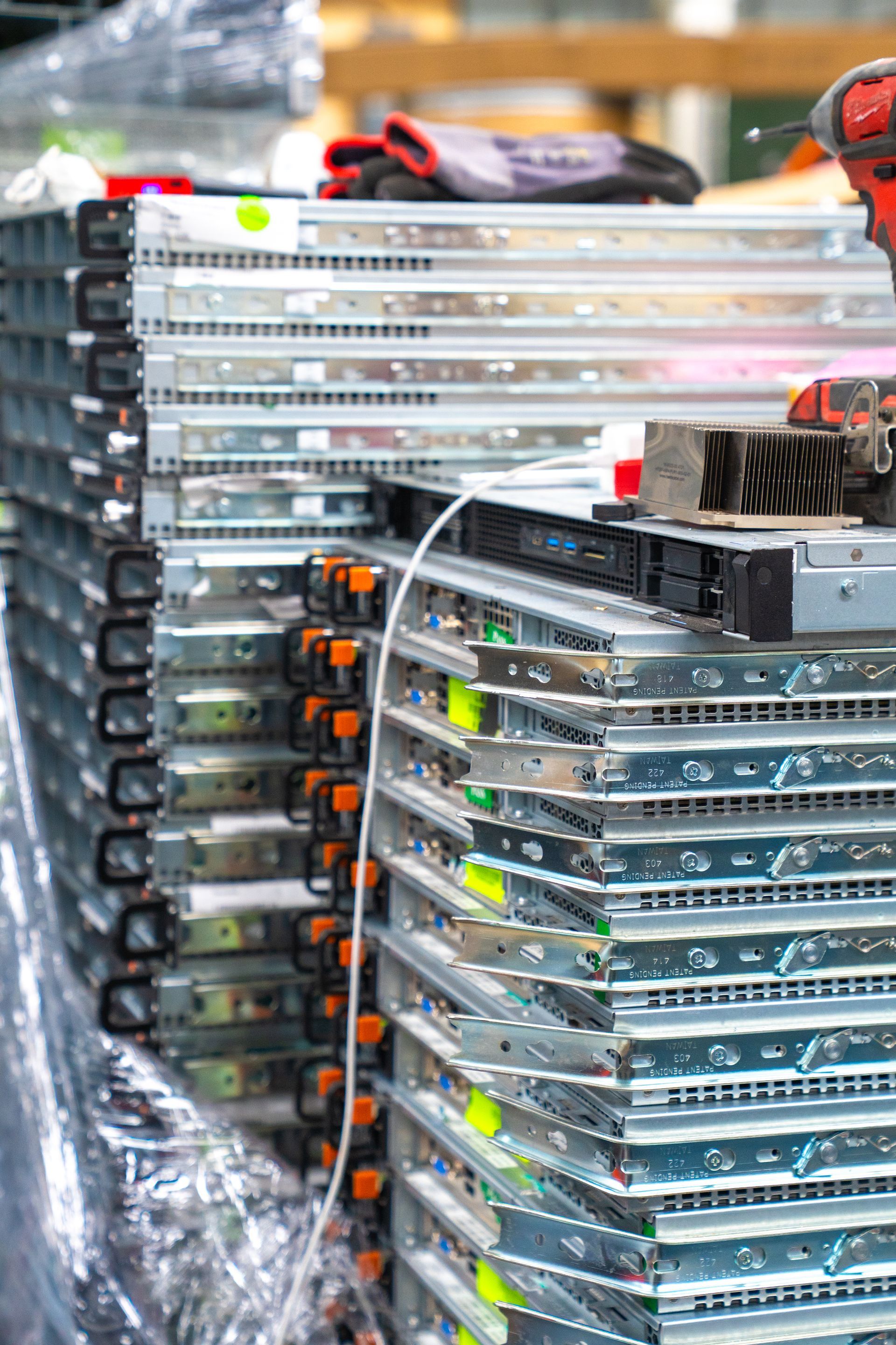 Stack of server racks, metal hardware, with colorful identification stickers.