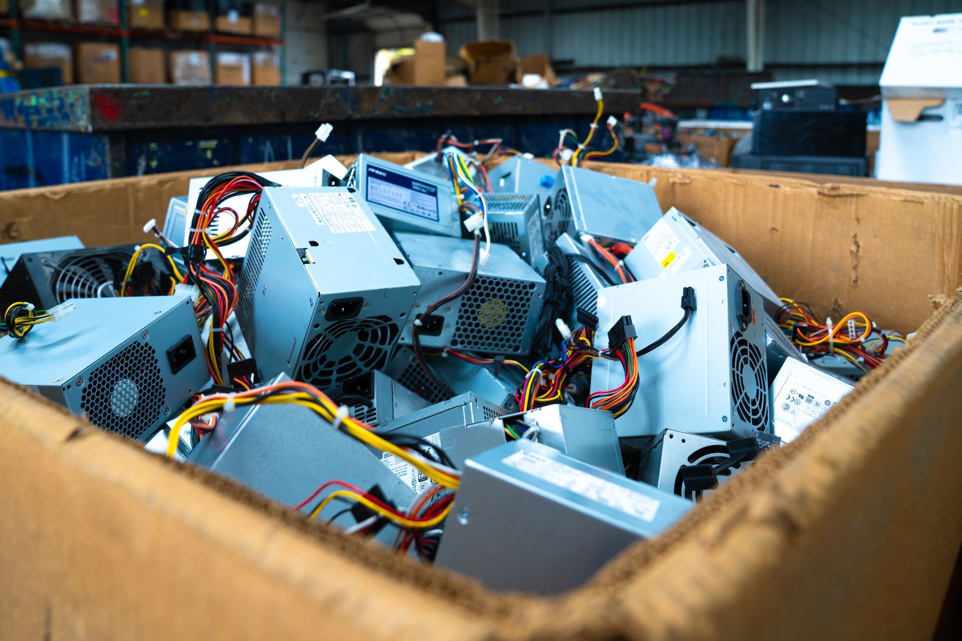 Cardboard box filled with discarded computer power supplies.