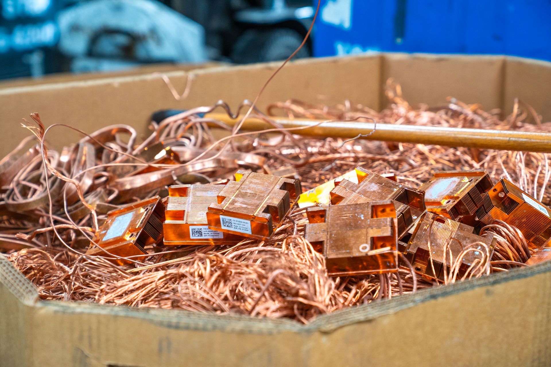 Copper scrap metal and computer parts in cardboard box.