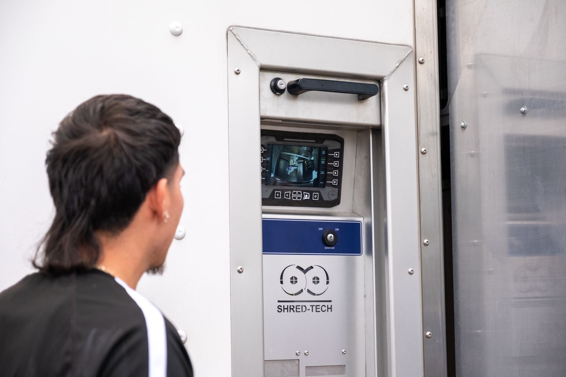 Man looking at a screen in a silver, blue and white security panel.