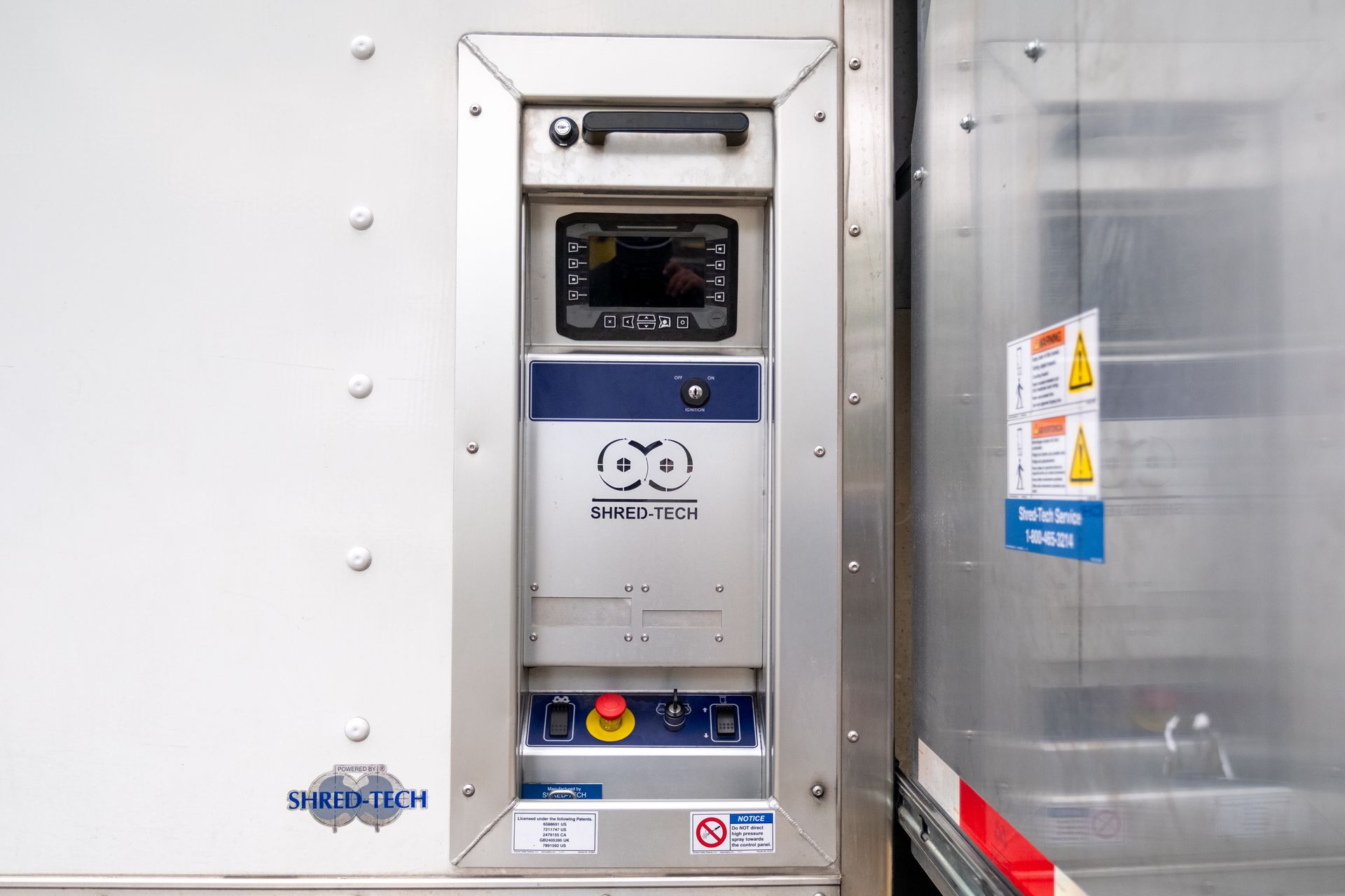 Control panel on a refrigerated trailer, with display, buttons, and handle. Silver and white colors.