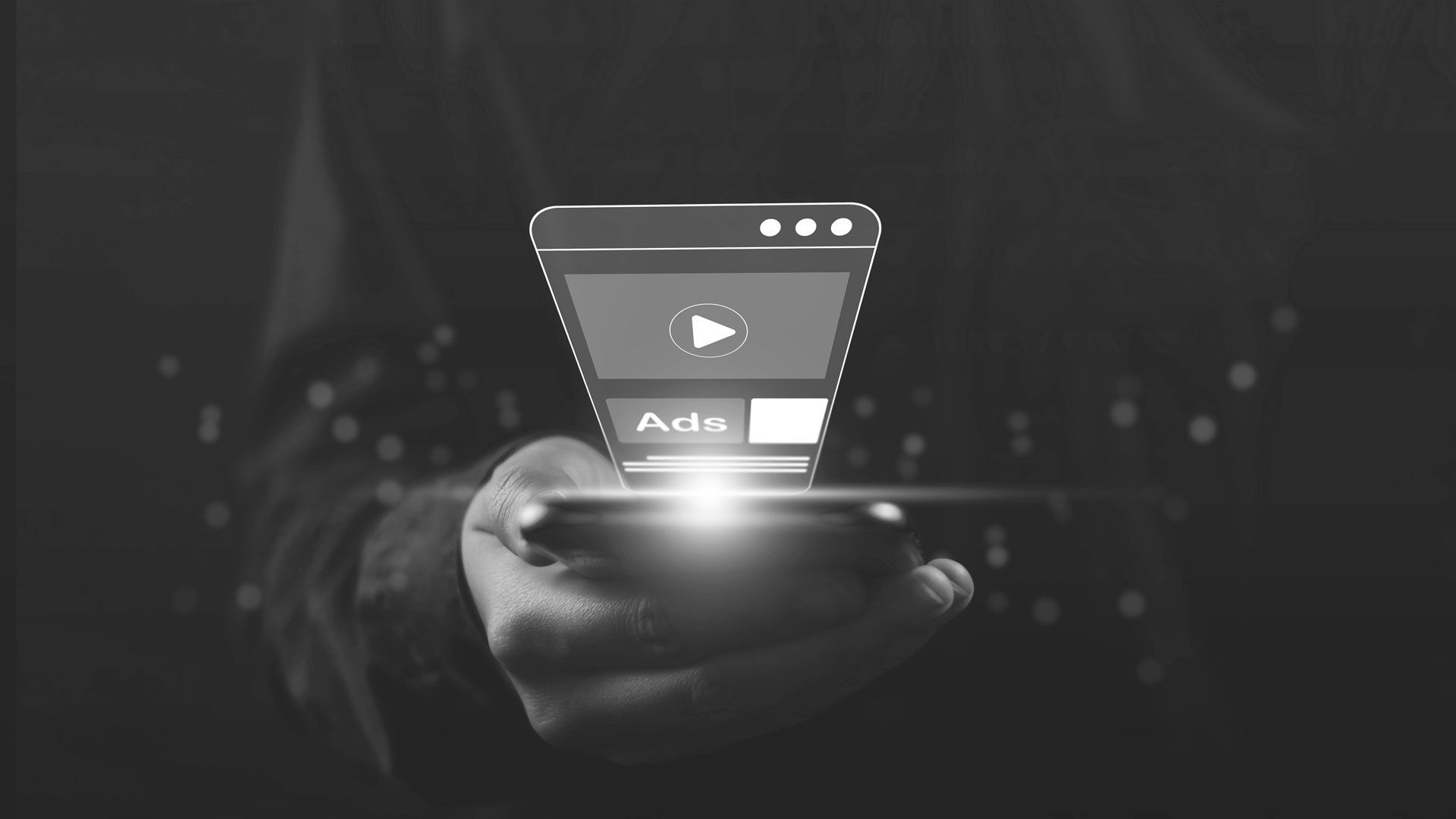 A person is holding a smart phone in their hand with a play button on the screen.
