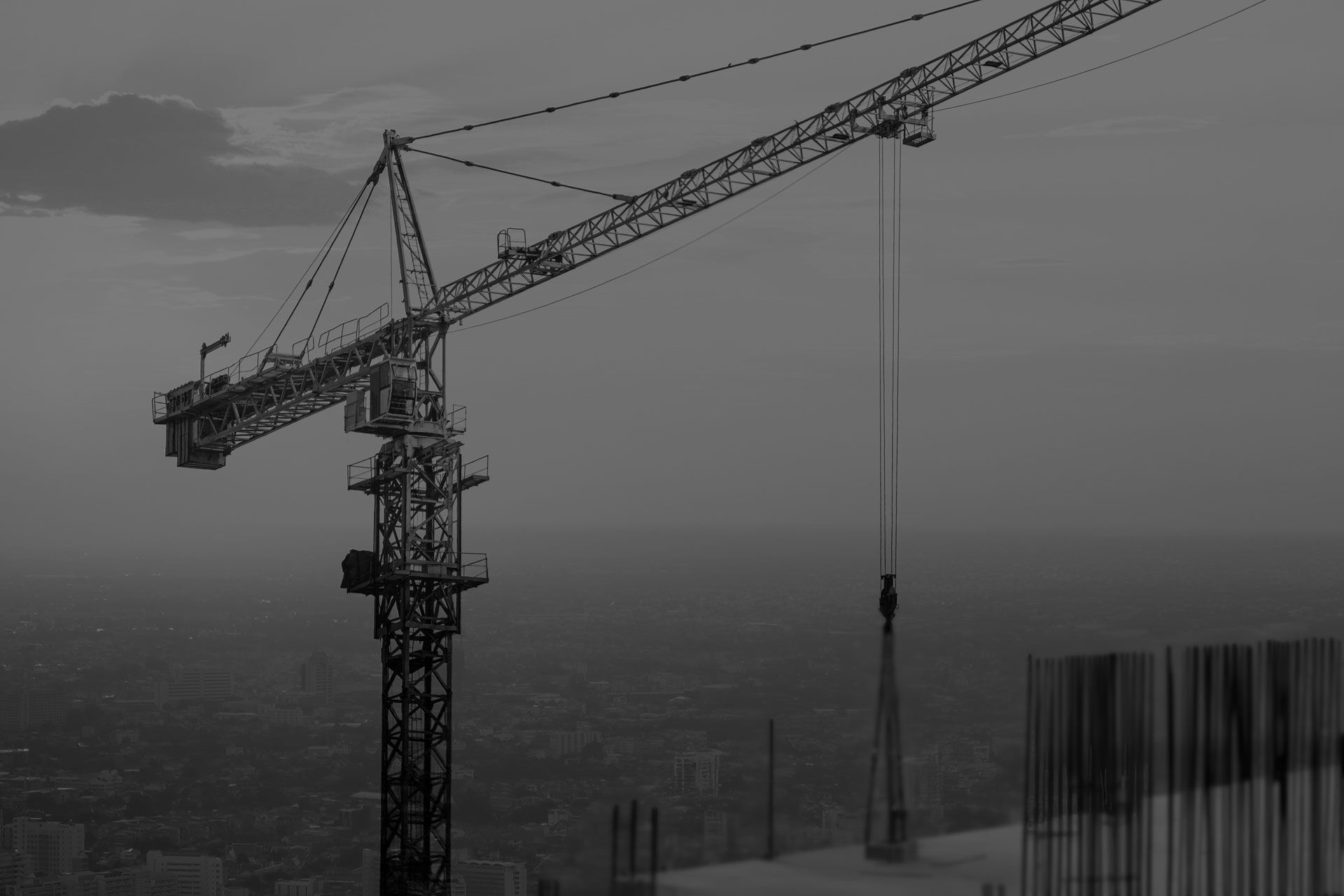 A black and white photo of a construction crane in the fog.