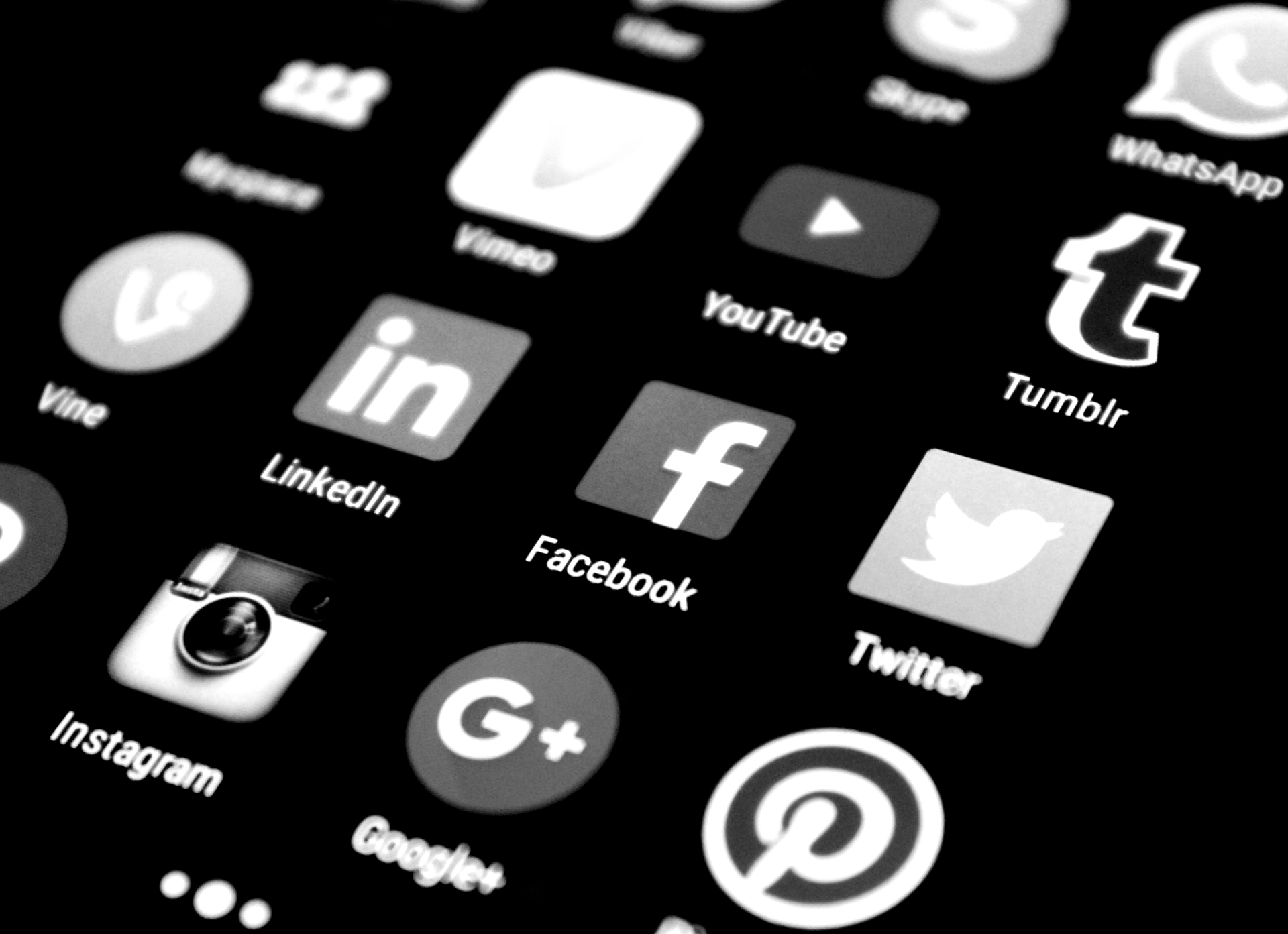Hands at a desk with a calculator, coffee, and a notebook with social media icons