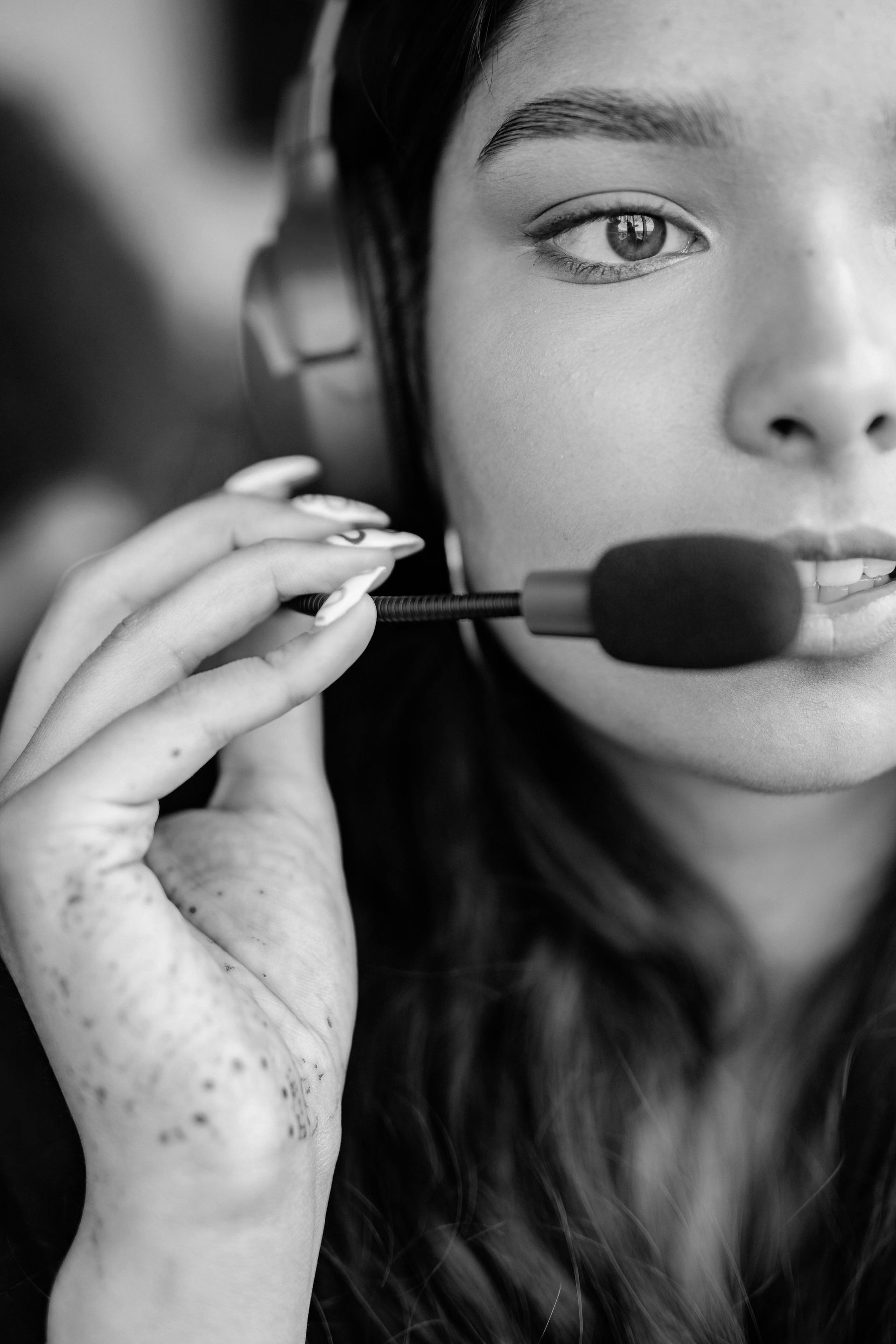 A black and white photo of a woman wearing headphones and a microphone.