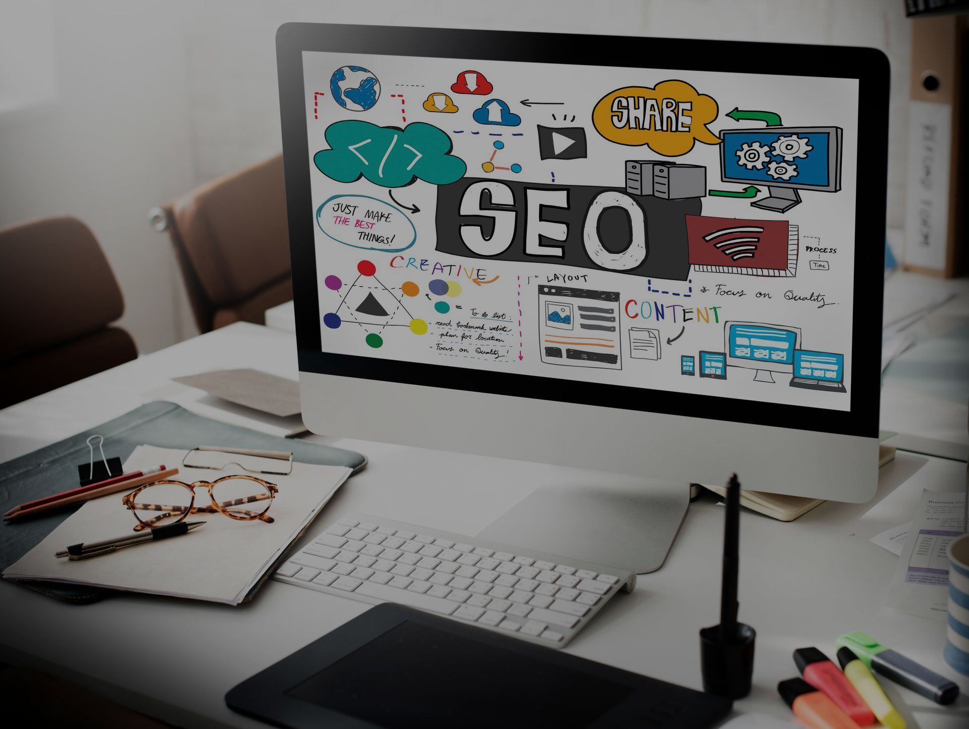 Desktop computer displaying SEO-related diagrams and the word