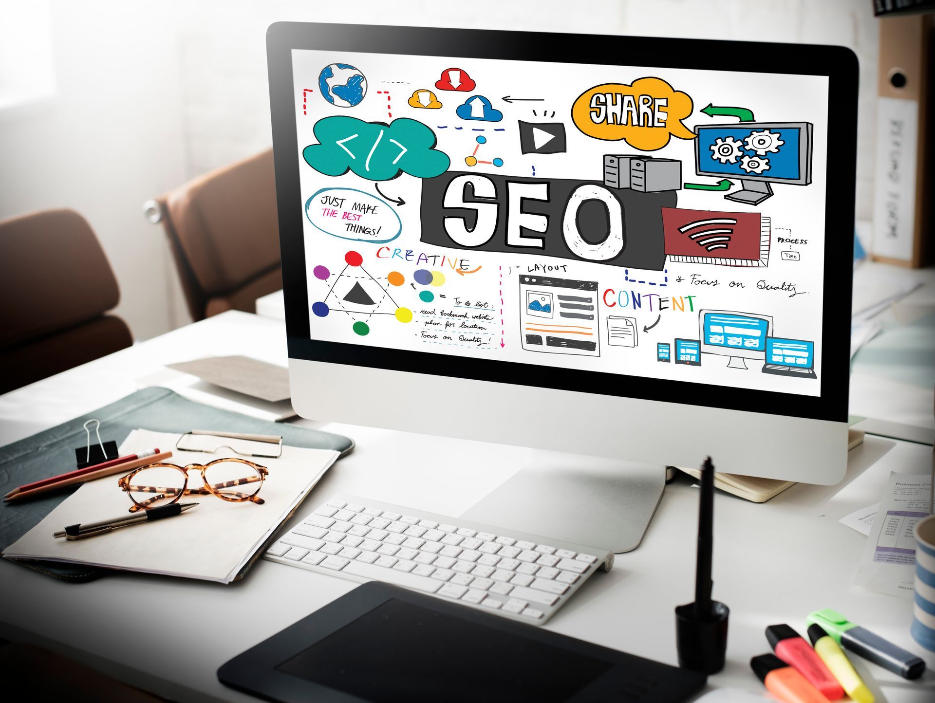 Desktop computer displaying SEO-related diagrams and the word