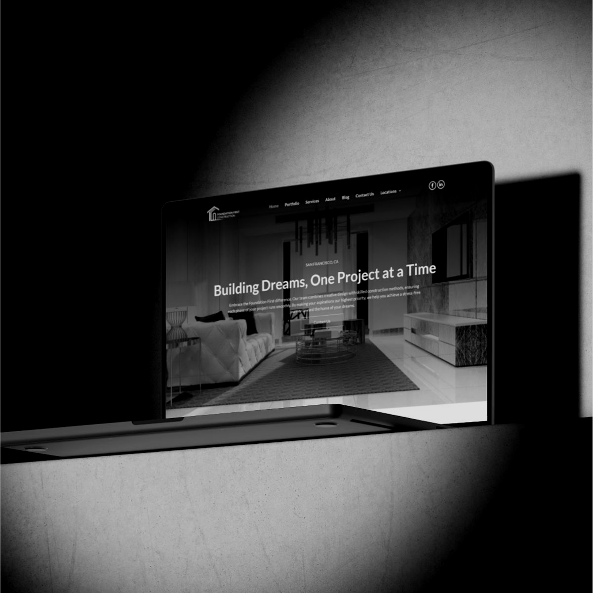 A black and white photo of a desk with a laptop and a computer.