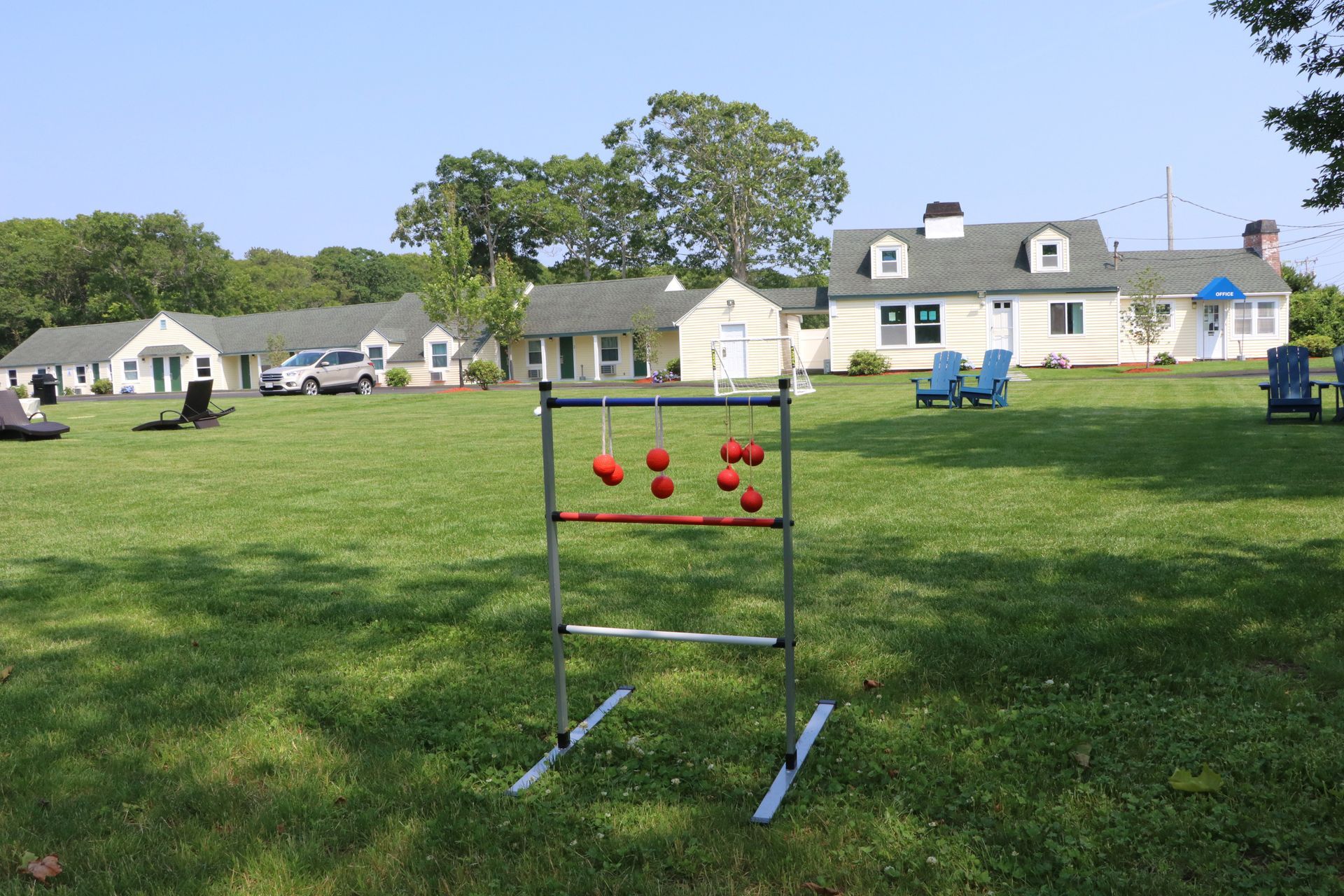 Ladder toss game set up on a grassy lawn with several buildings in the background.