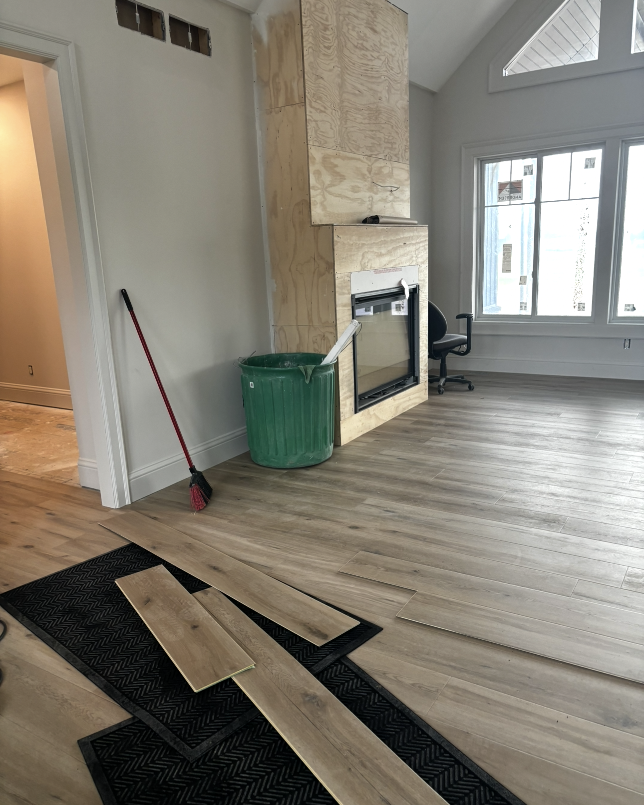 Person kneeling, cutting green flooring with a utility knife.