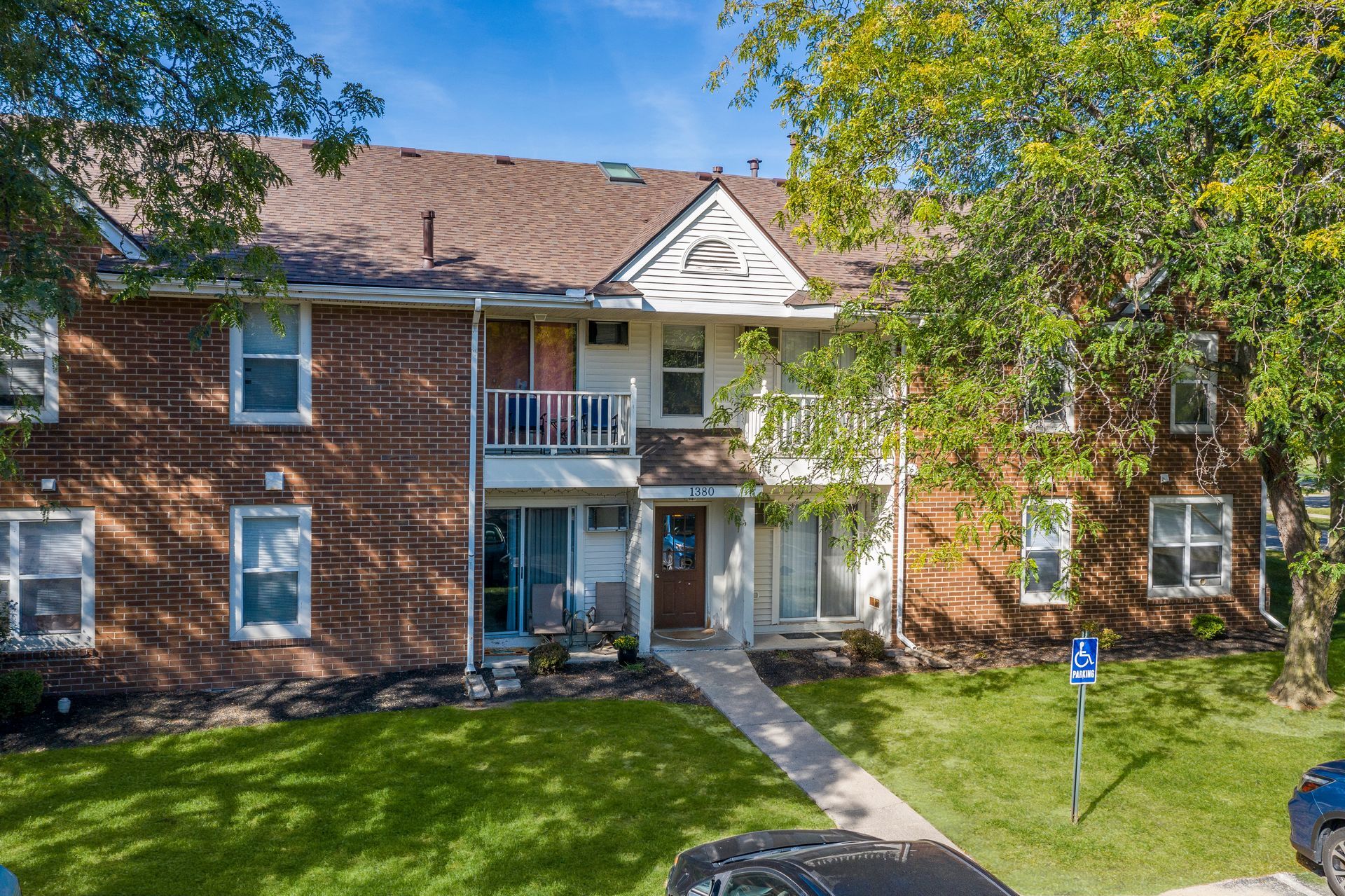 Photo of a two story brick building with a single pathway leading up to the front entrance