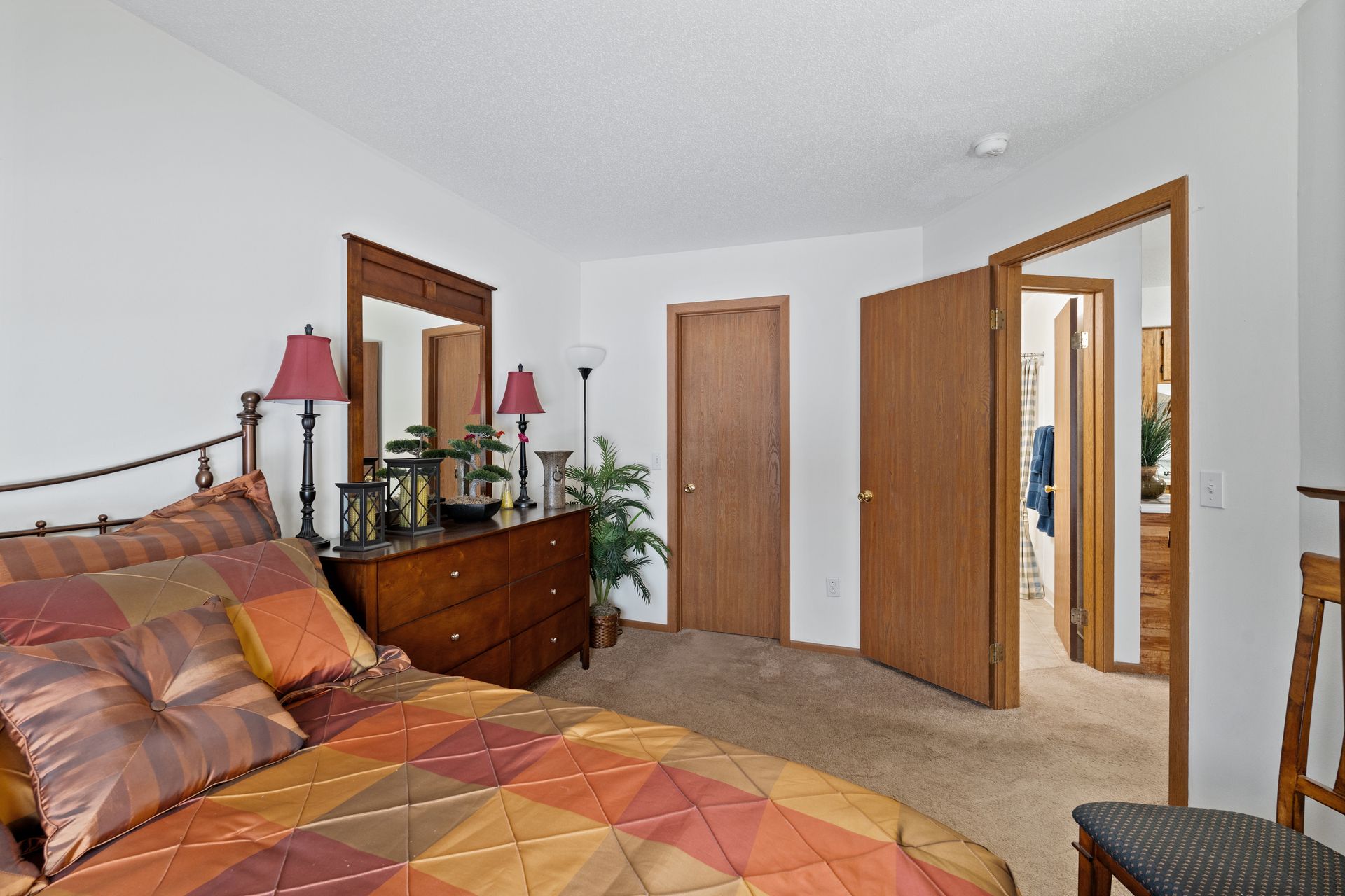 Photo of a bedroom, with a hallway in the background