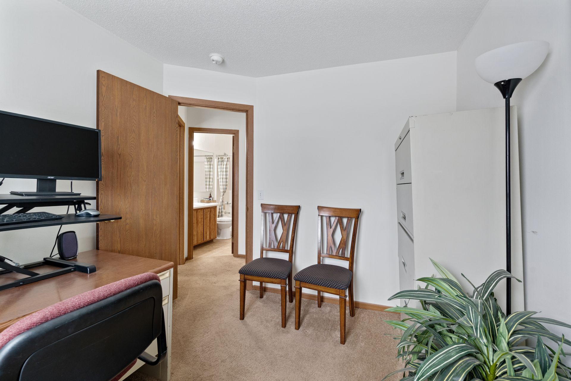 Photo of an office, showing a computer monitor and a couple of chairs