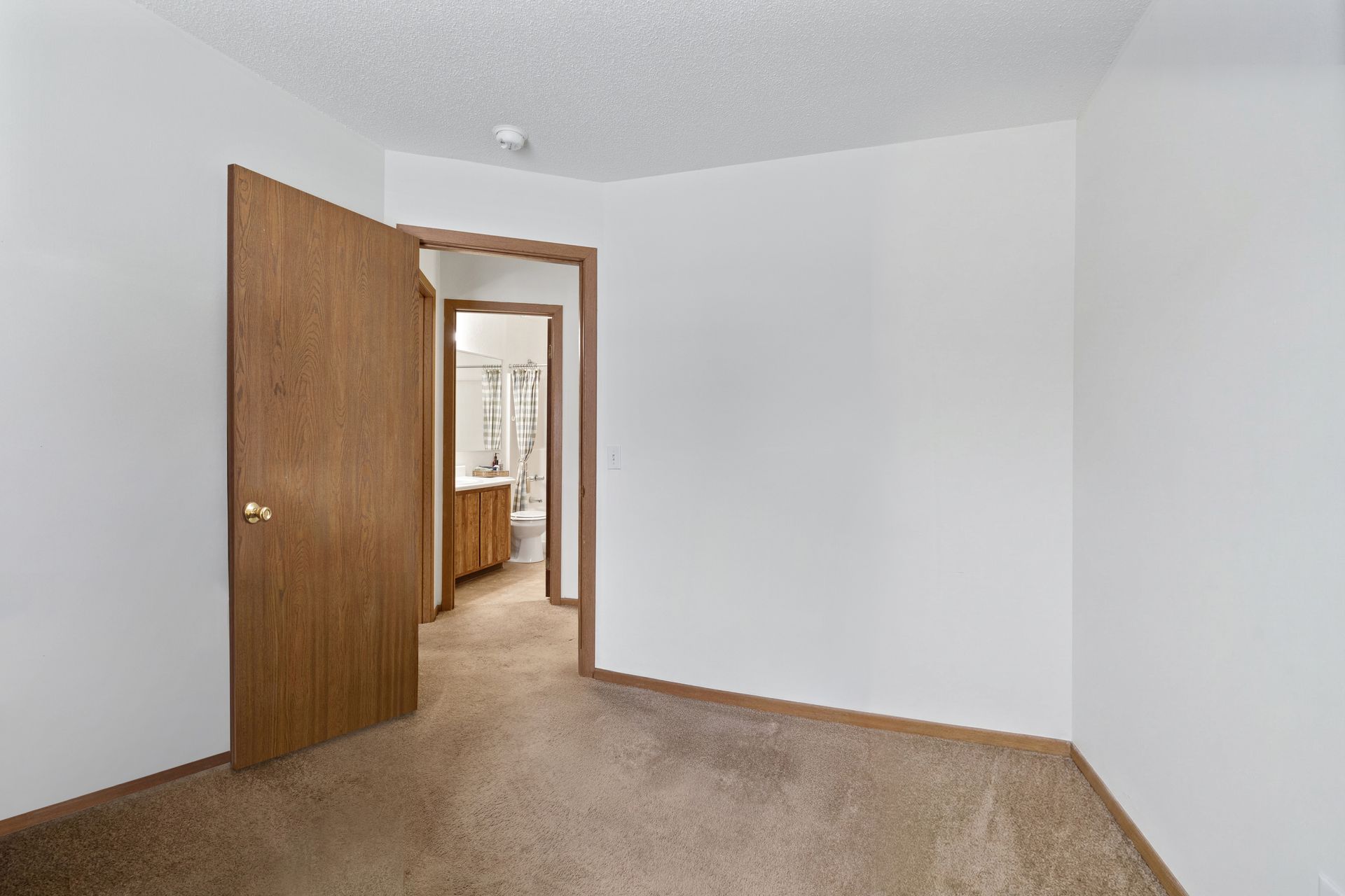 Photo of a room, with a bathroom in the background