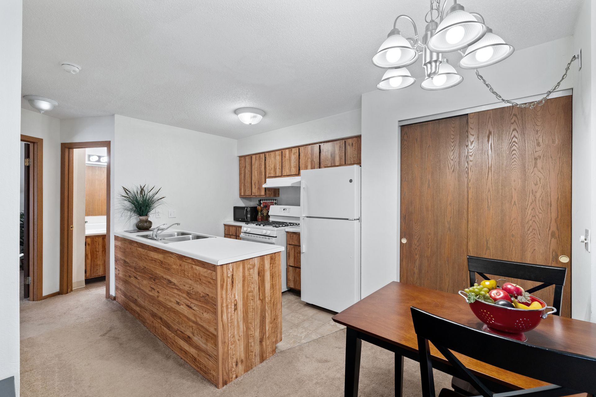 Photo of a kitchen with an island that has a sink, and the dining area is next to the kitchen