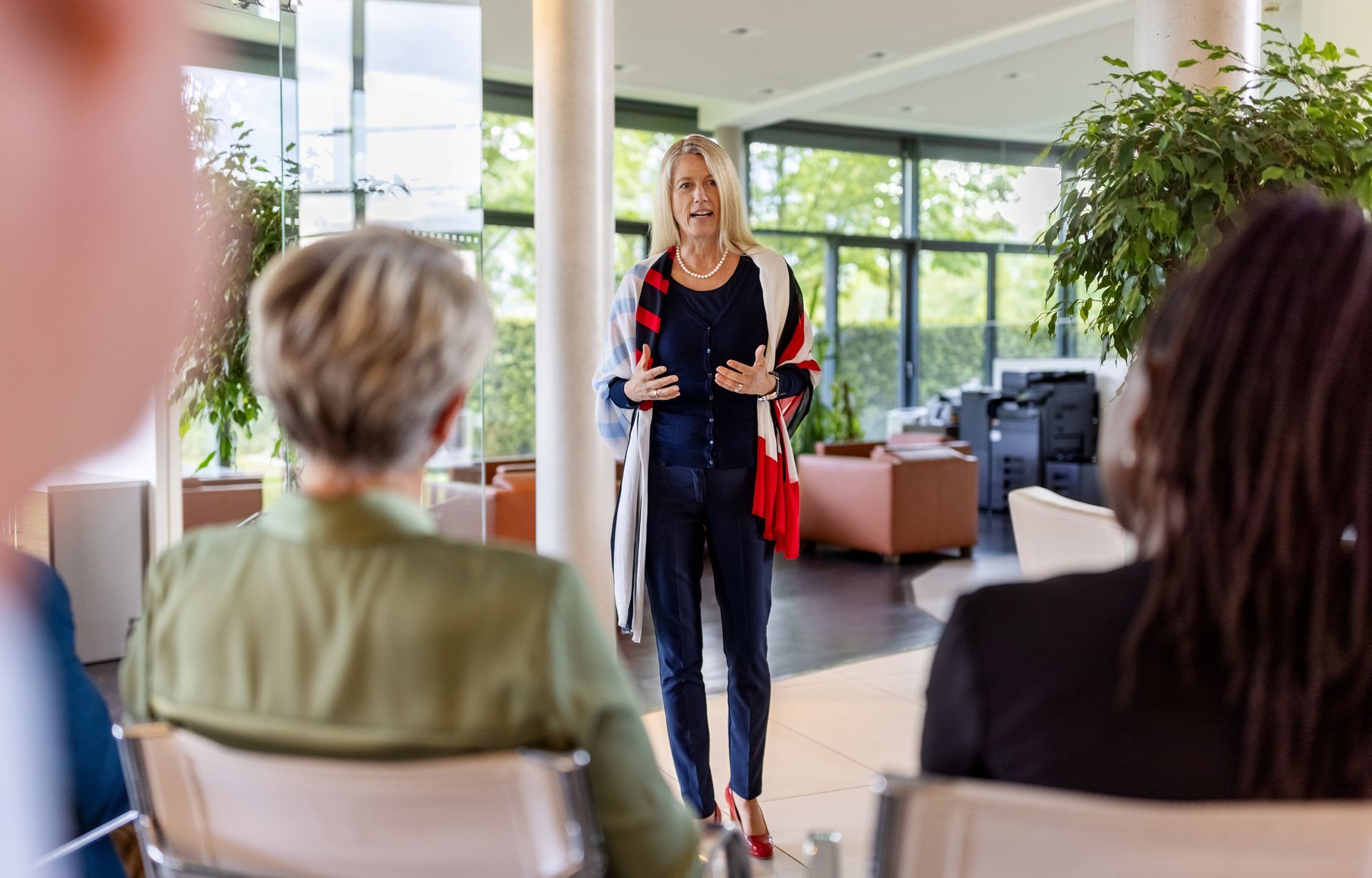 A woman is giving a presentation to a group of people sitting in chairs.