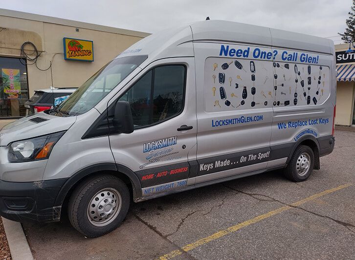 White service van with “Need One? Call Gil!” ad parked outside a store in a lot