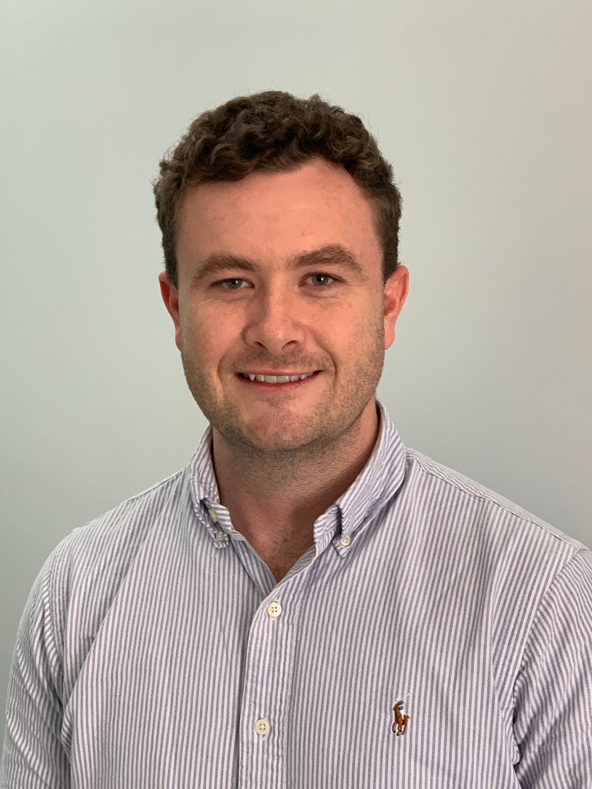 A man in a striped shirt is smiling for the camera.
