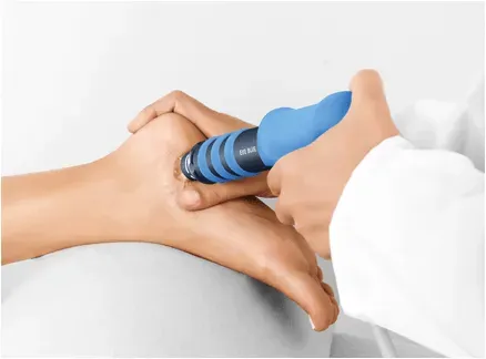 Podiatrist performing shockwave therapy on a patient’s foot to relieve heel pain and promote healing