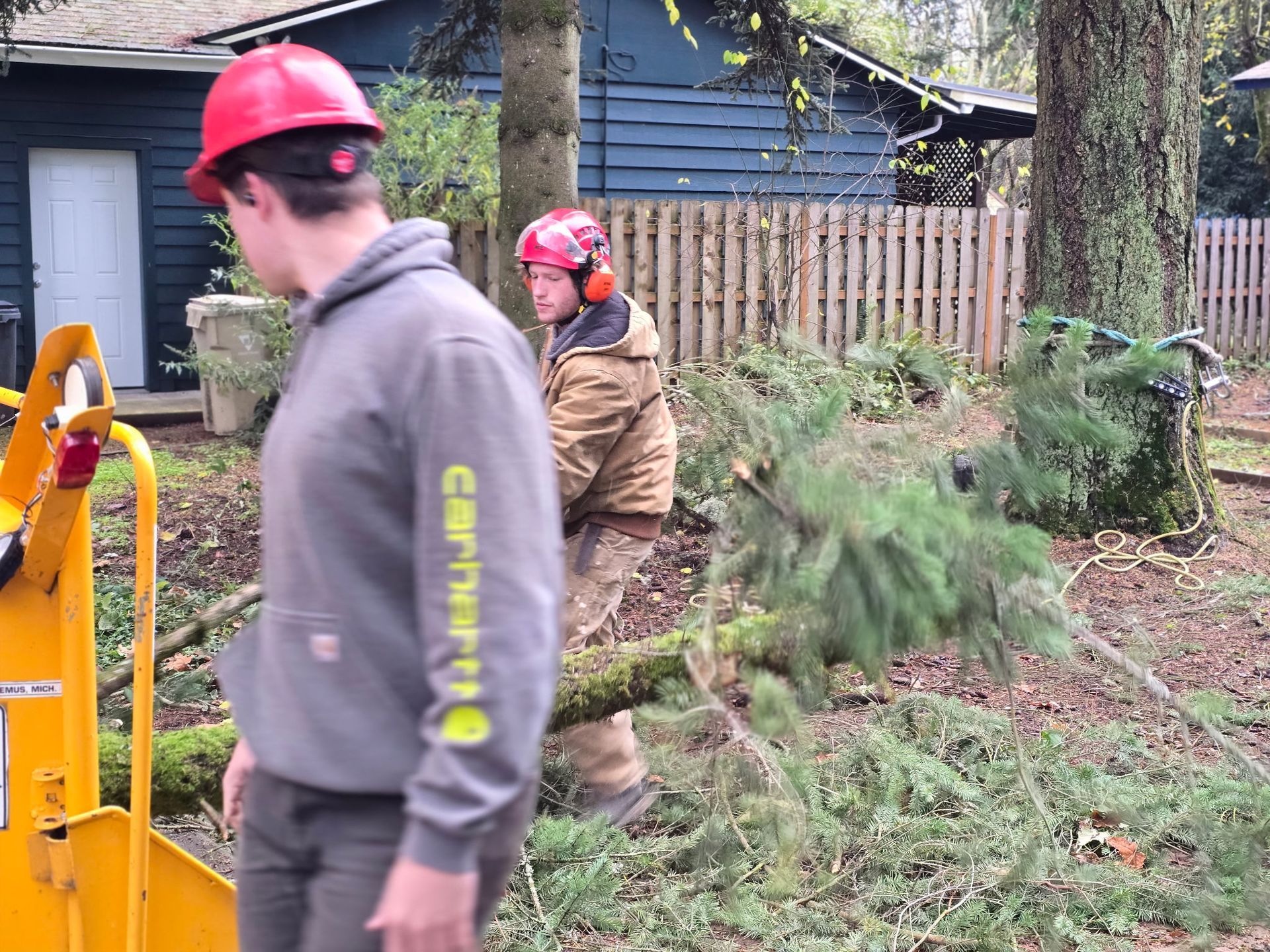 A man wearing a carhartt sweatshirt is standing next to another man