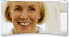 Elderly woman smiling confidently wearing new dentures