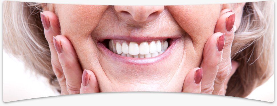 Elderly woman smiling with delight with her hands on her cheeks