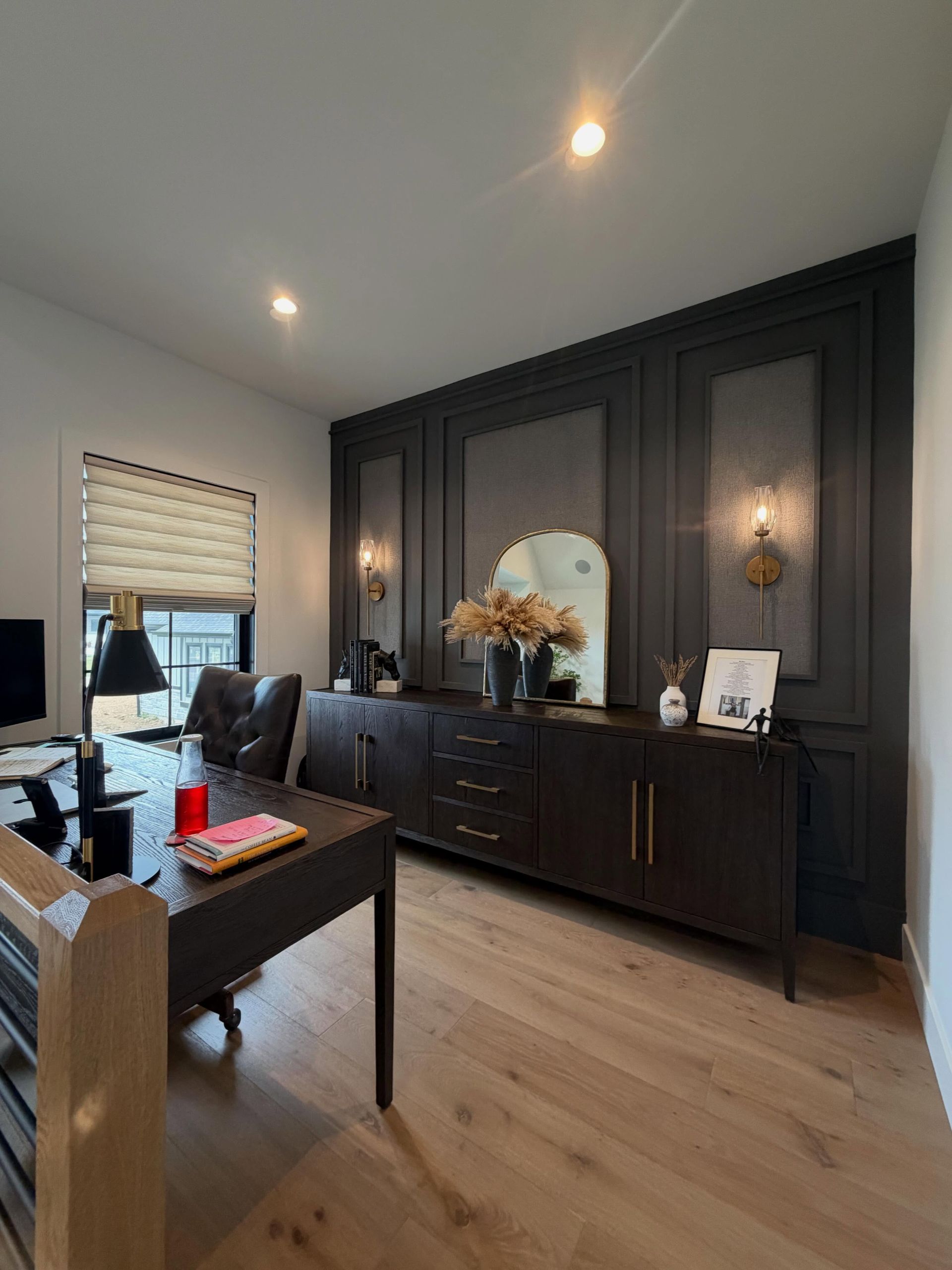 Stylish home office with dark wood cabinetry, a desk, and a window with blinds