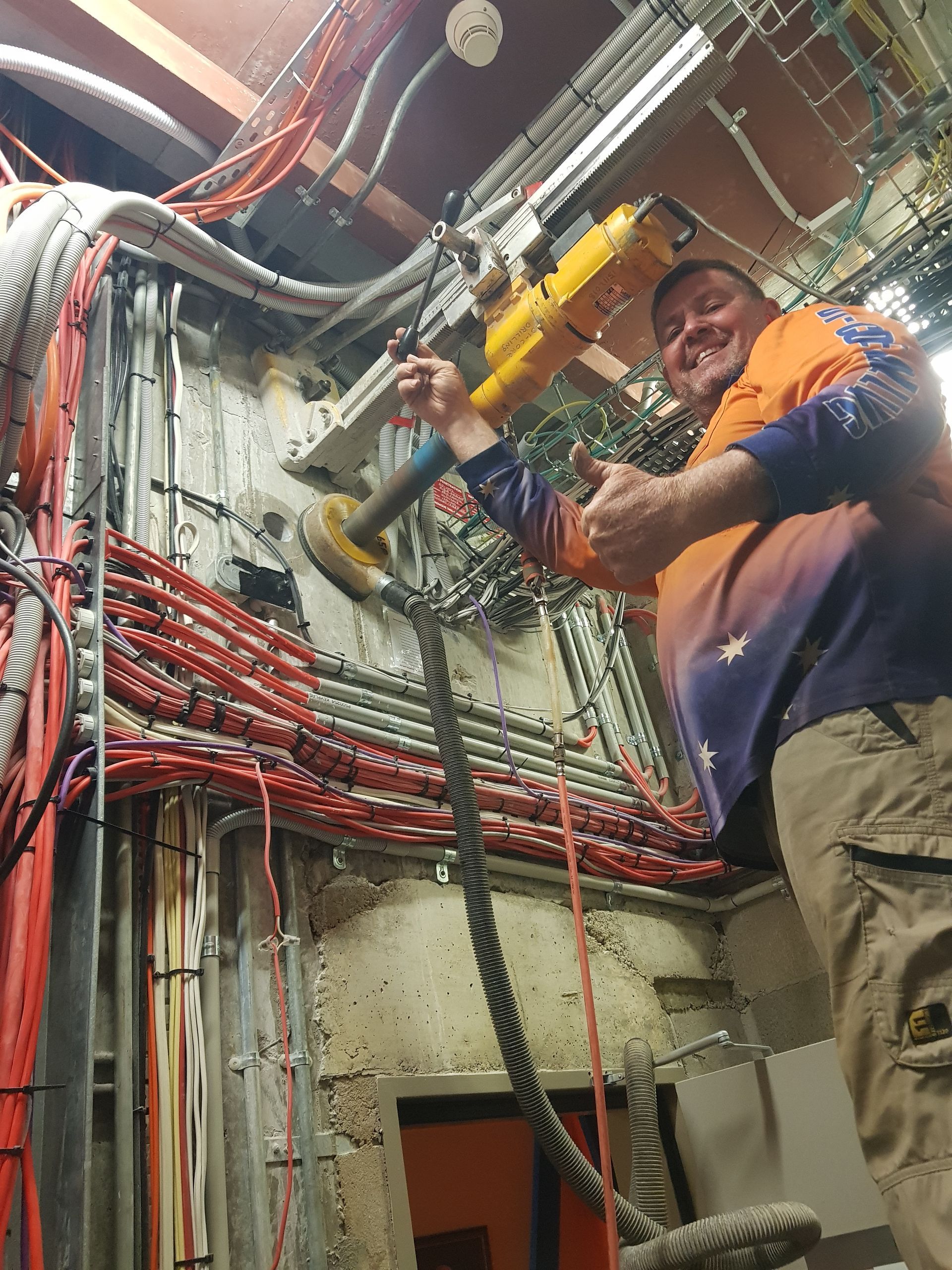 A Man Is Using a Wall Drill in a Facility — Di-Core Drilling and Cutting in Humpty Doo, NT