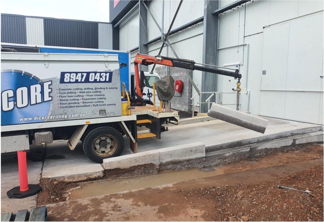 A truck with a crane beside a building under construction — Di-Core Drilling and Cutting in Darwin, NT