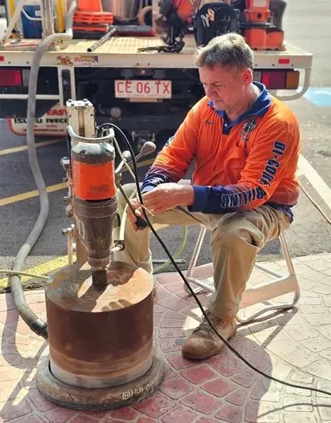 A Person is Using Core Drilling Machine — Di-Core Drilling and Cutting in Darwin, NT