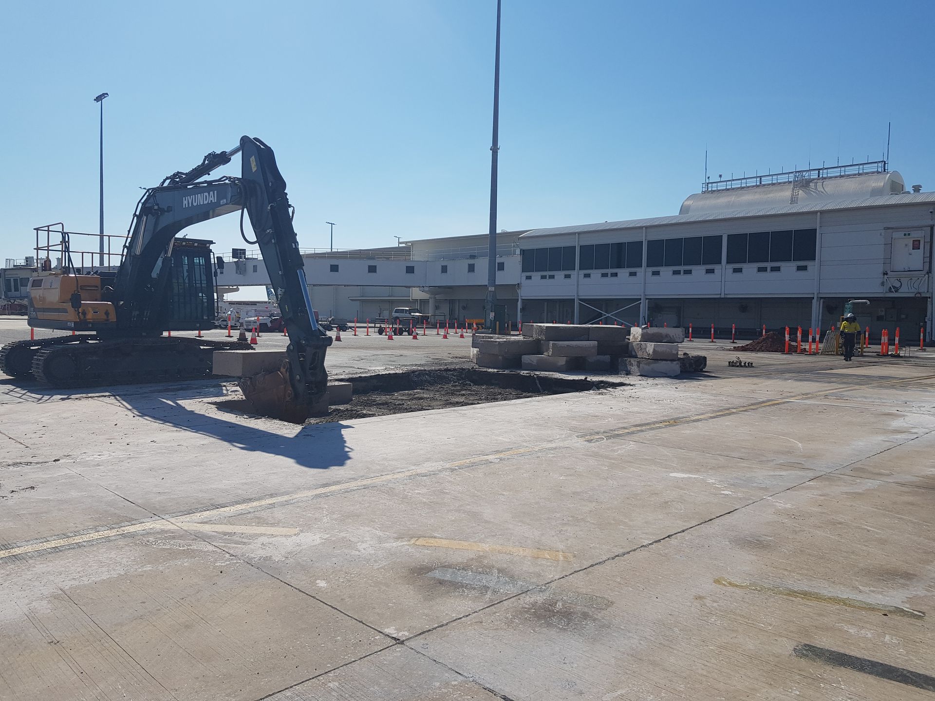 An excavator digs a hole in a concrete area— Di-Core Drilling and Cutting in Darwin, NT