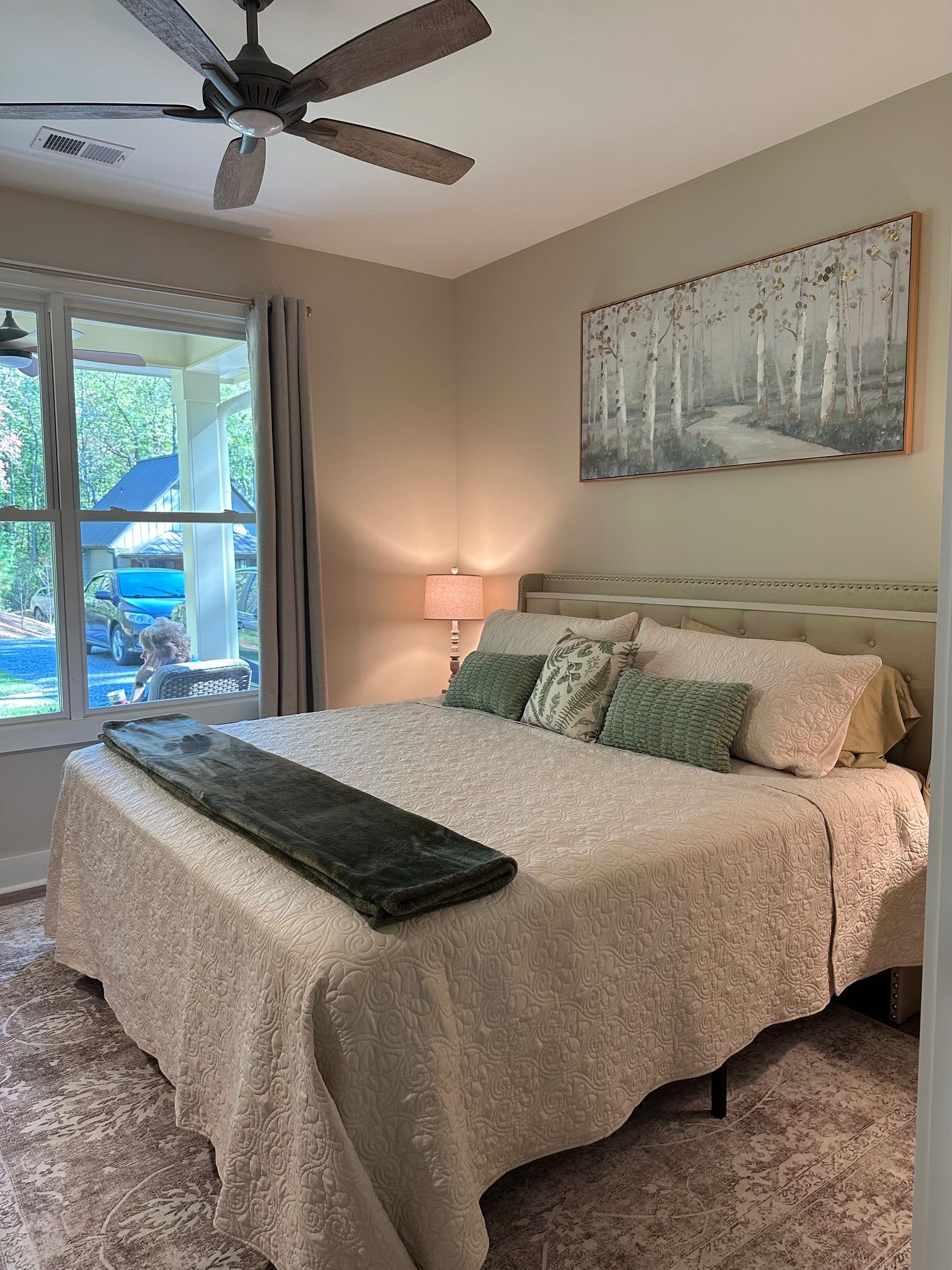 A bedroom with a king size bed and a ceiling fan.