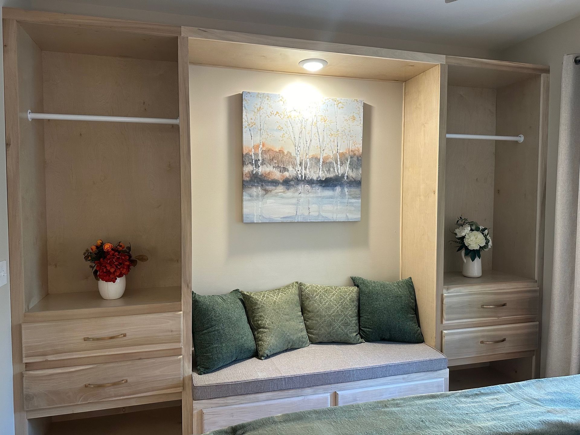 A bedroom with a couch and a painting on the wall.