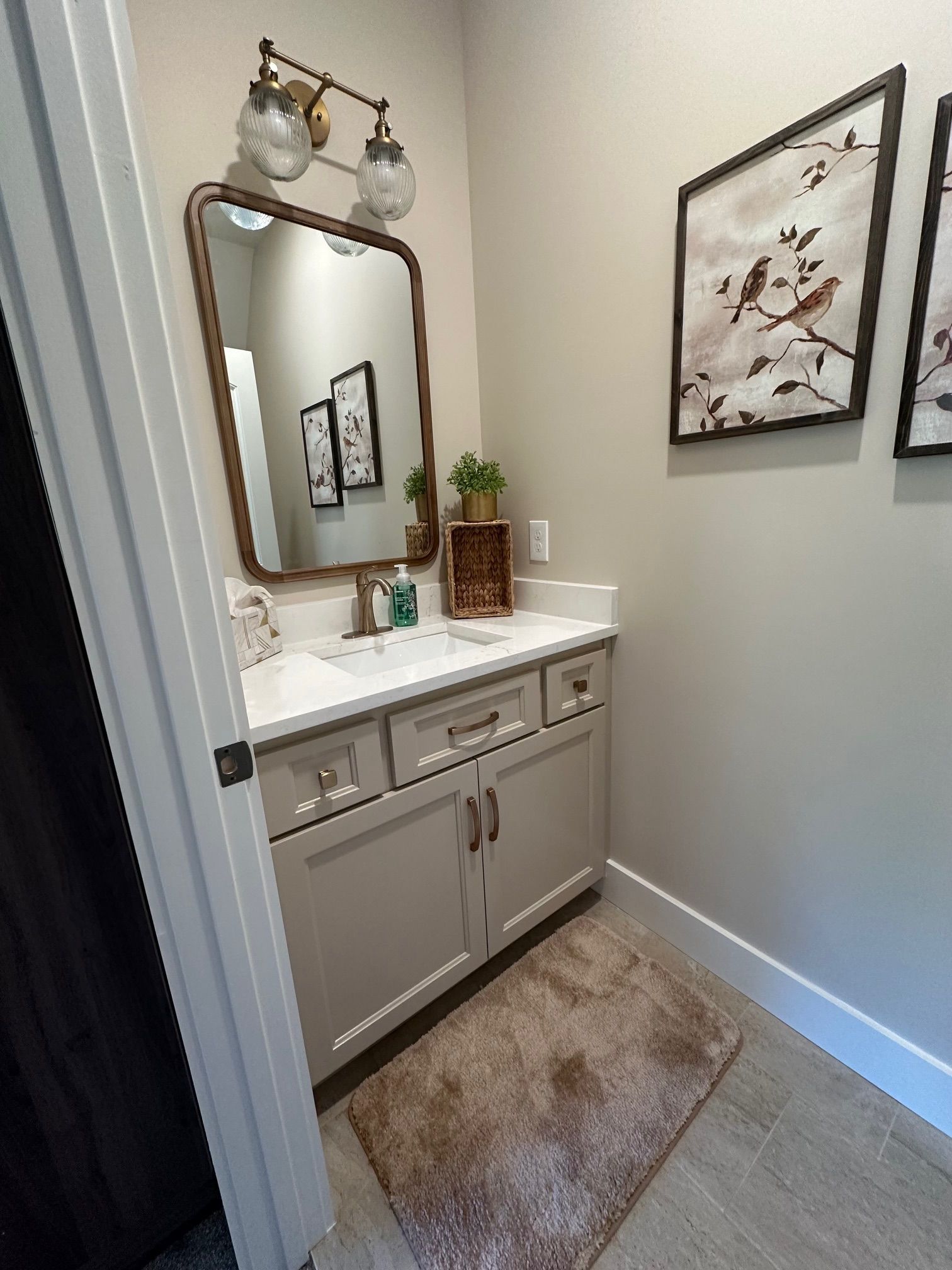 A bathroom with a sink , mirror , and rug.