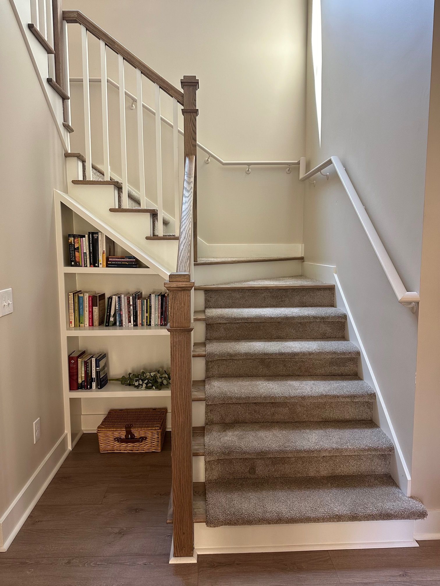 A staircase with a bookshelf underneath it