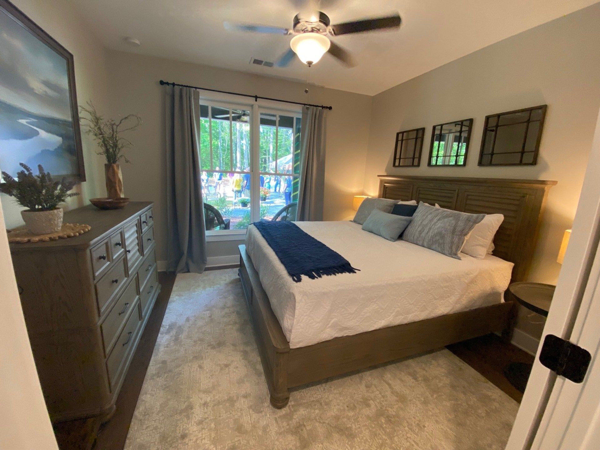 A bedroom with a king size bed and a ceiling fan.
