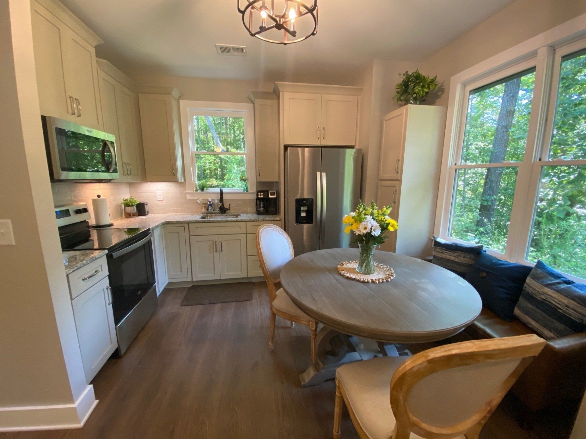 A kitchen with a table and chairs and a refrigerator.