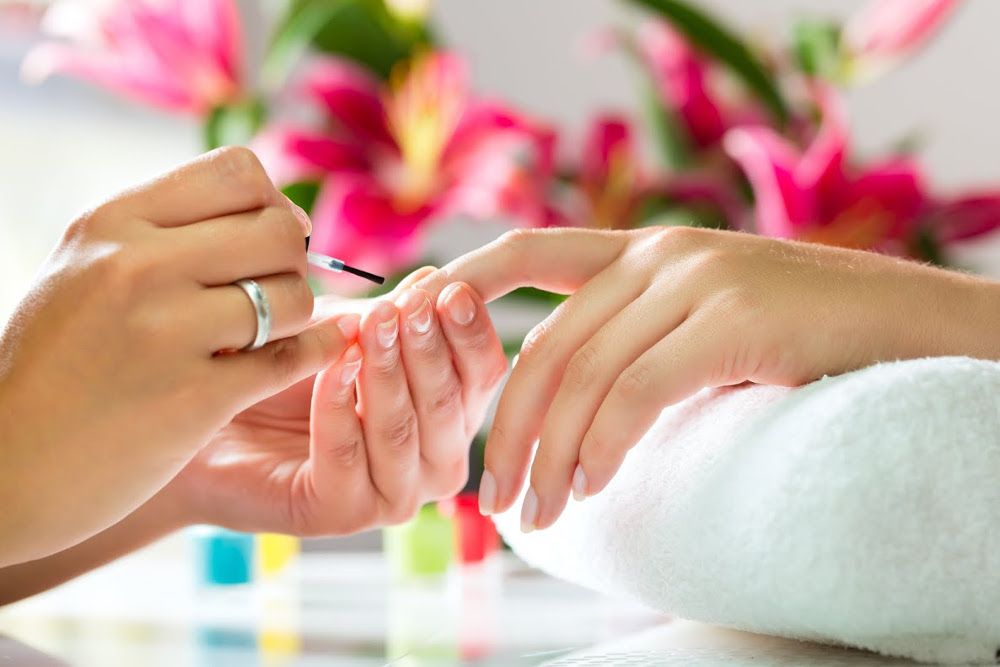 Eine Frau lässt sich in einem Nagelstudio die Nägel lackieren.