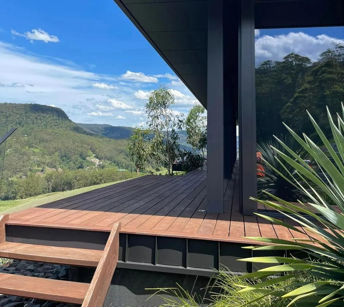 A Wooden Deck With Stairs Leading Up to It and Mountains in the Background — South Coast Pressure Washer in Warilla, NSW