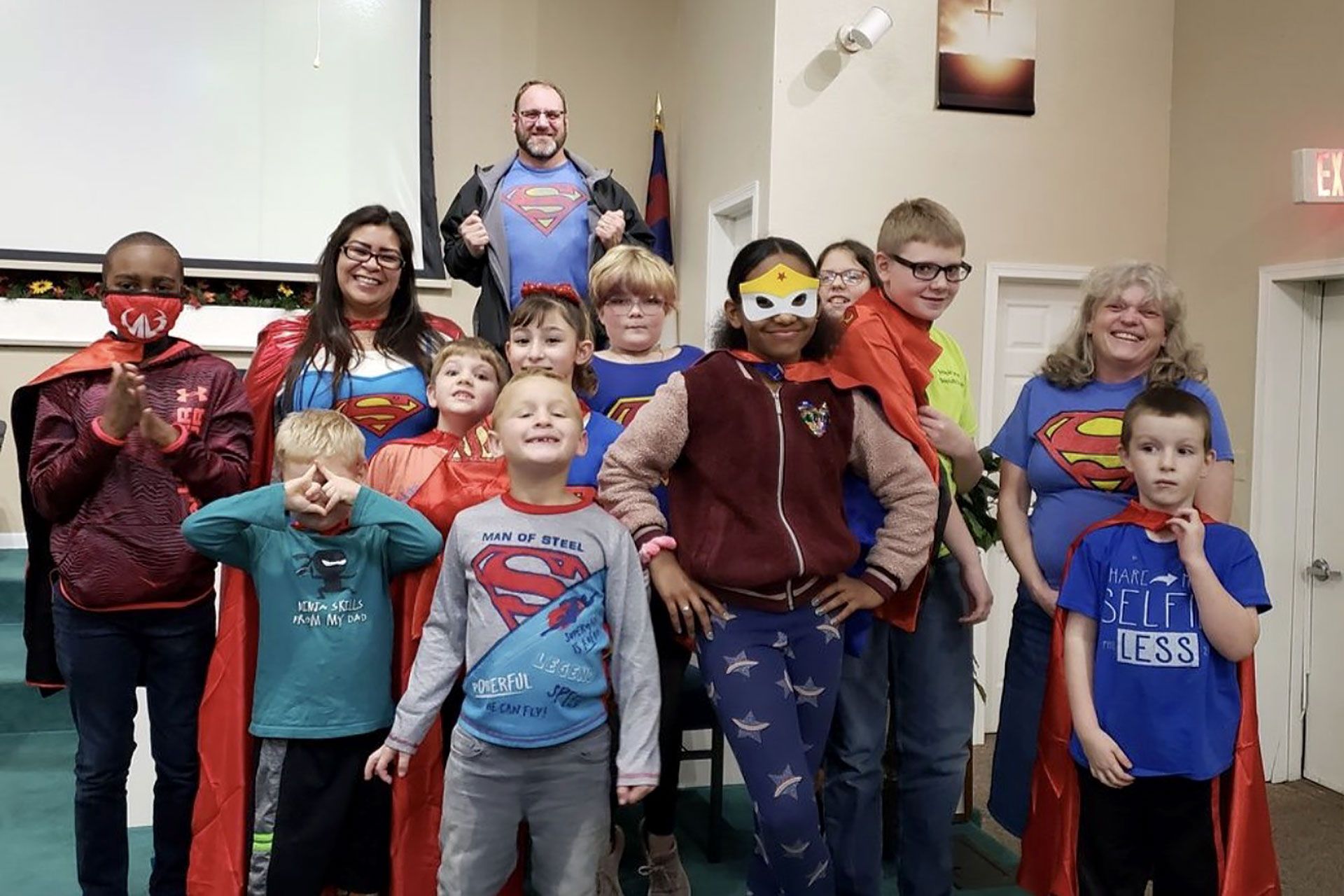 A group of children dressed as superheroes are posing for a picture.