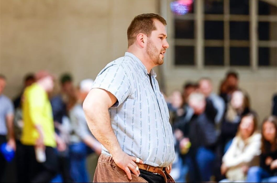 Ein Schwinger steht in einem Raum mit einer Menschenmenge.