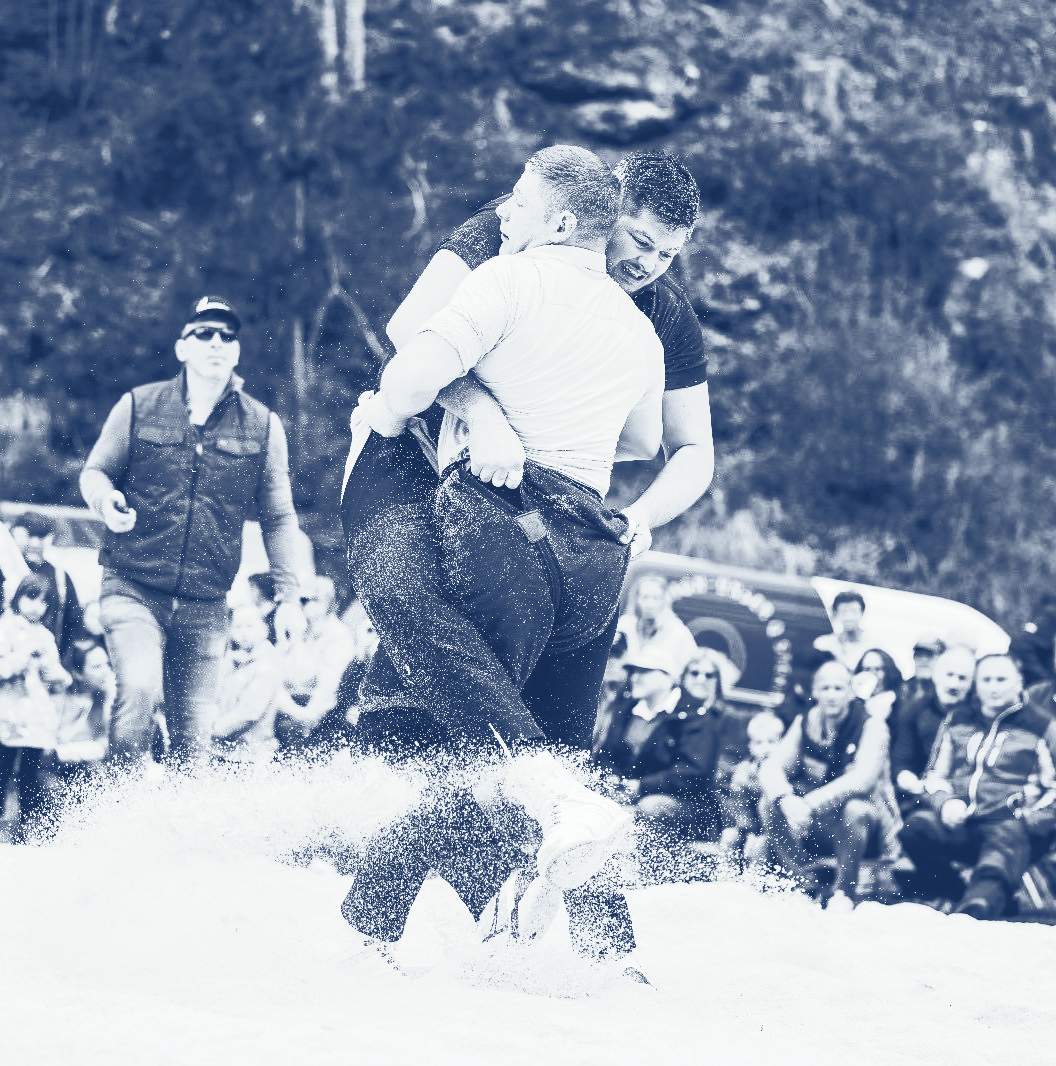 Zwei Männer Schwingen; Zuschauer schauen zu.