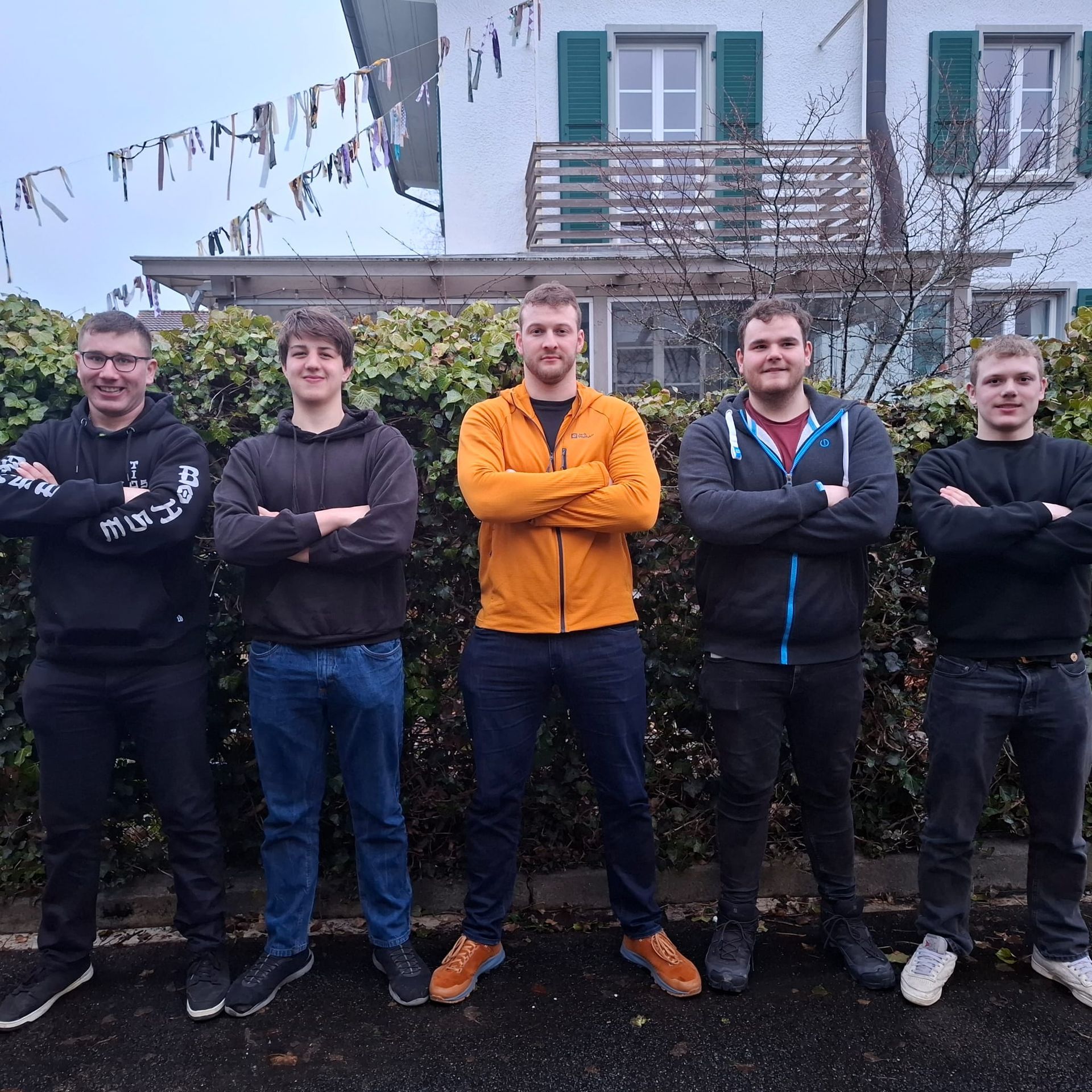 Zwei Männer Schwingen im Sägemehl, einer in Weiß, der andere in Beige; im Hintergrund ist eine Zuschauermenge zu sehen.