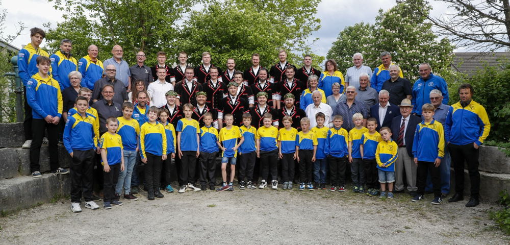 Eine Gruppe von Personen in blauen und gelben Jacken im Freien.