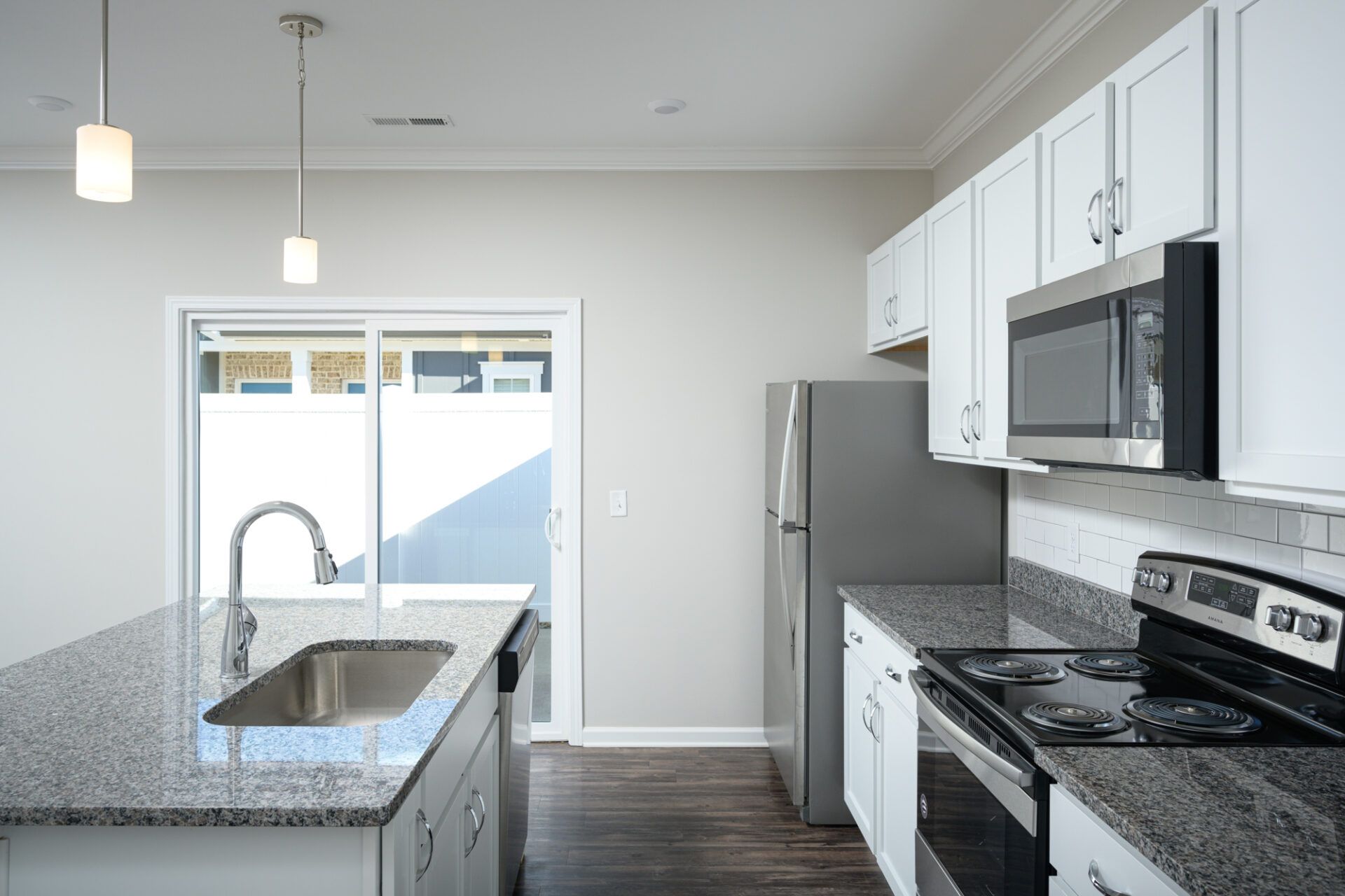 A kitchen with granite counter tops , stainless steel appliances , and white cabinets  at Ashford Villas in Chattanooga, TN.