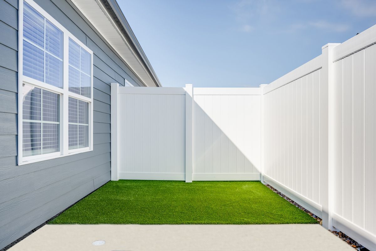 There is a white fence in the backyard of a house at Ashford Villas in Chattanooga, TN.