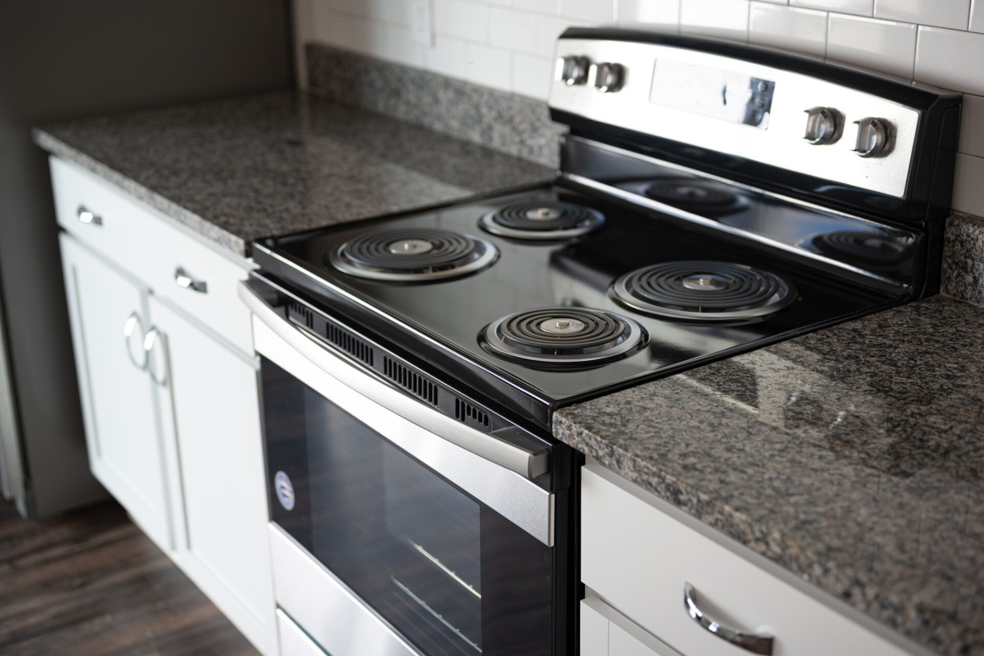 A stove top oven is sitting on top of a granite counter in a kitchen at Ashford Villas in Chattanooga, TN.