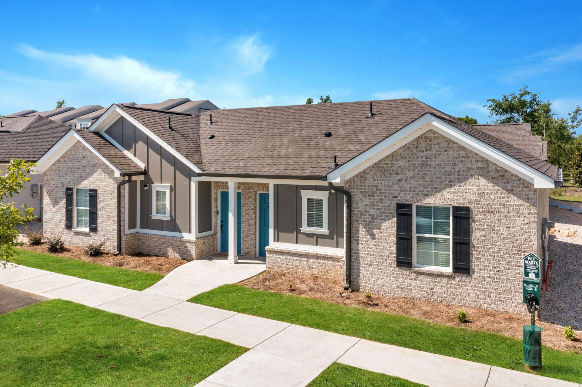 An aerial view of a brick house with a sidewalk in front of it at Ashford Villas in Chattanooga, TN.
