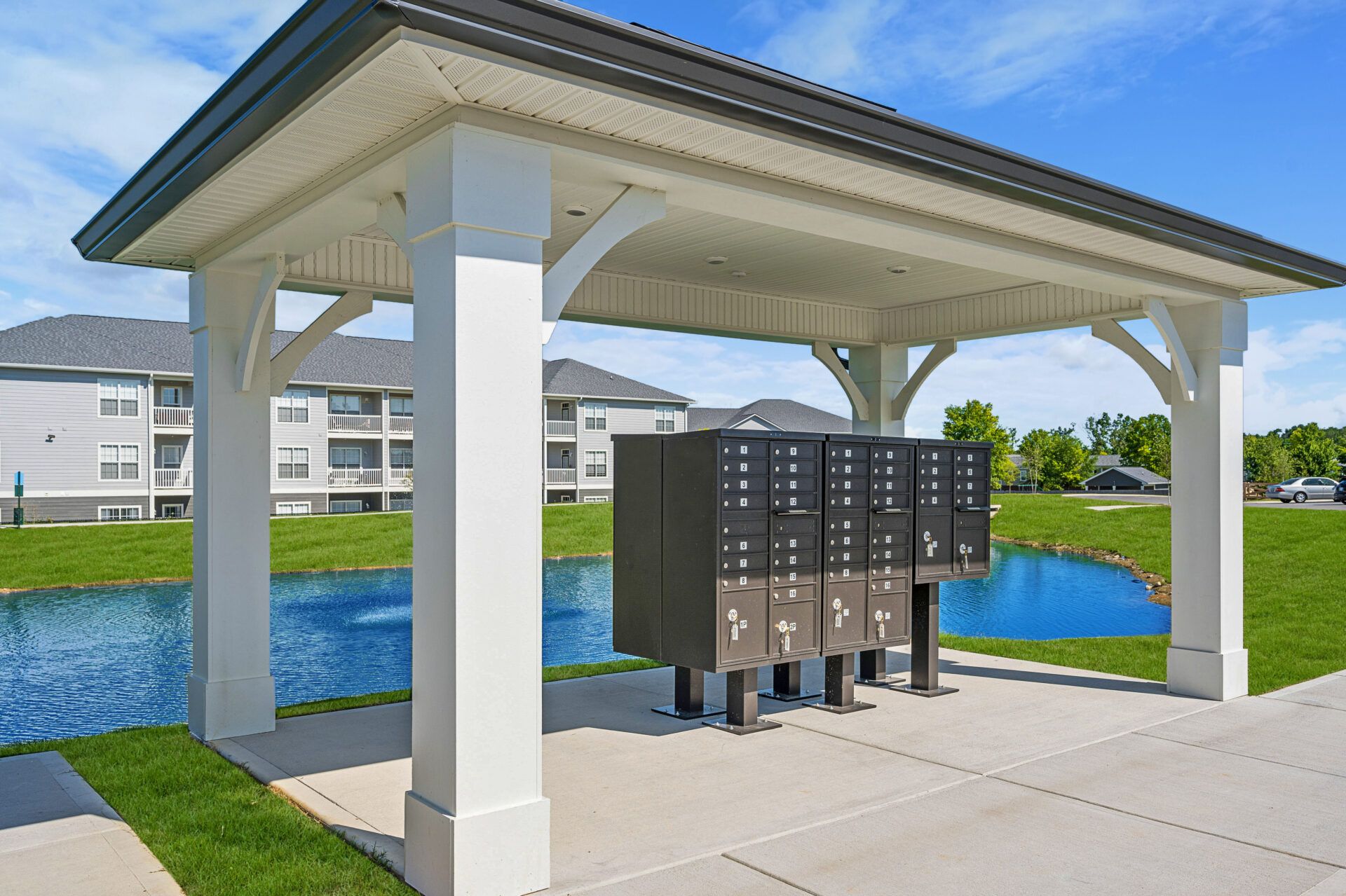 A row of mailboxes under a gazebo with a pond in the background at Ashford Villas in Chattanooga, TN.