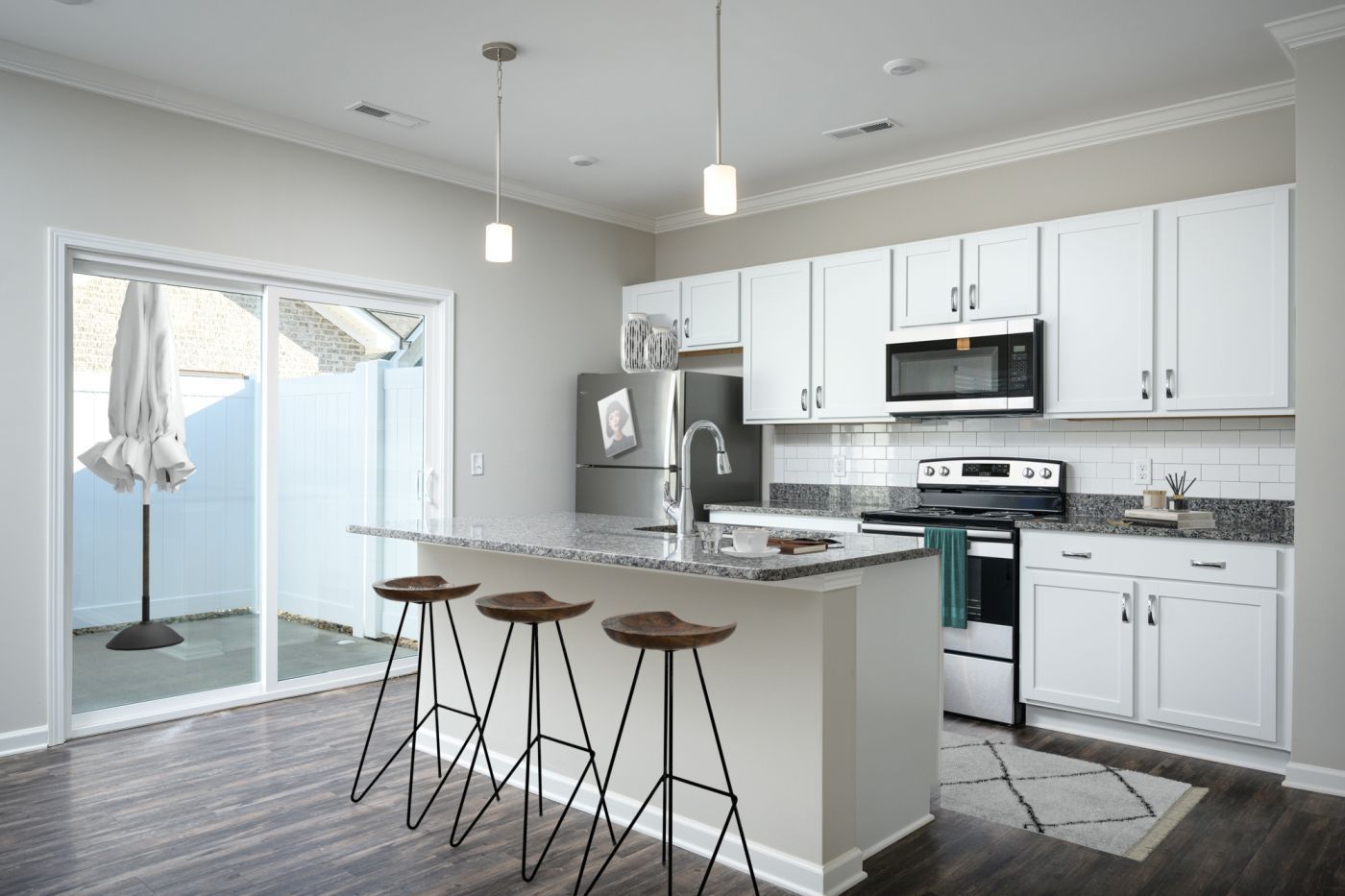 A kitchen with white cabinets , stainless steel appliances and granite counter tops.